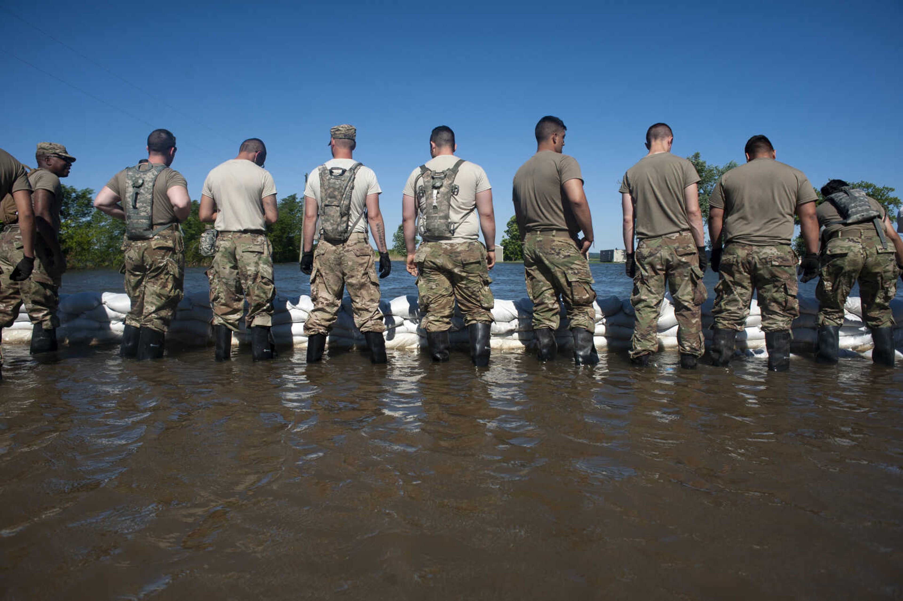 Members of the Illinois National Guard build up existing sandbag barriers to hold back floodwaters Monday, June 10, 2019, along Brookwood Drive in East Cape Girardeau, Illinois.