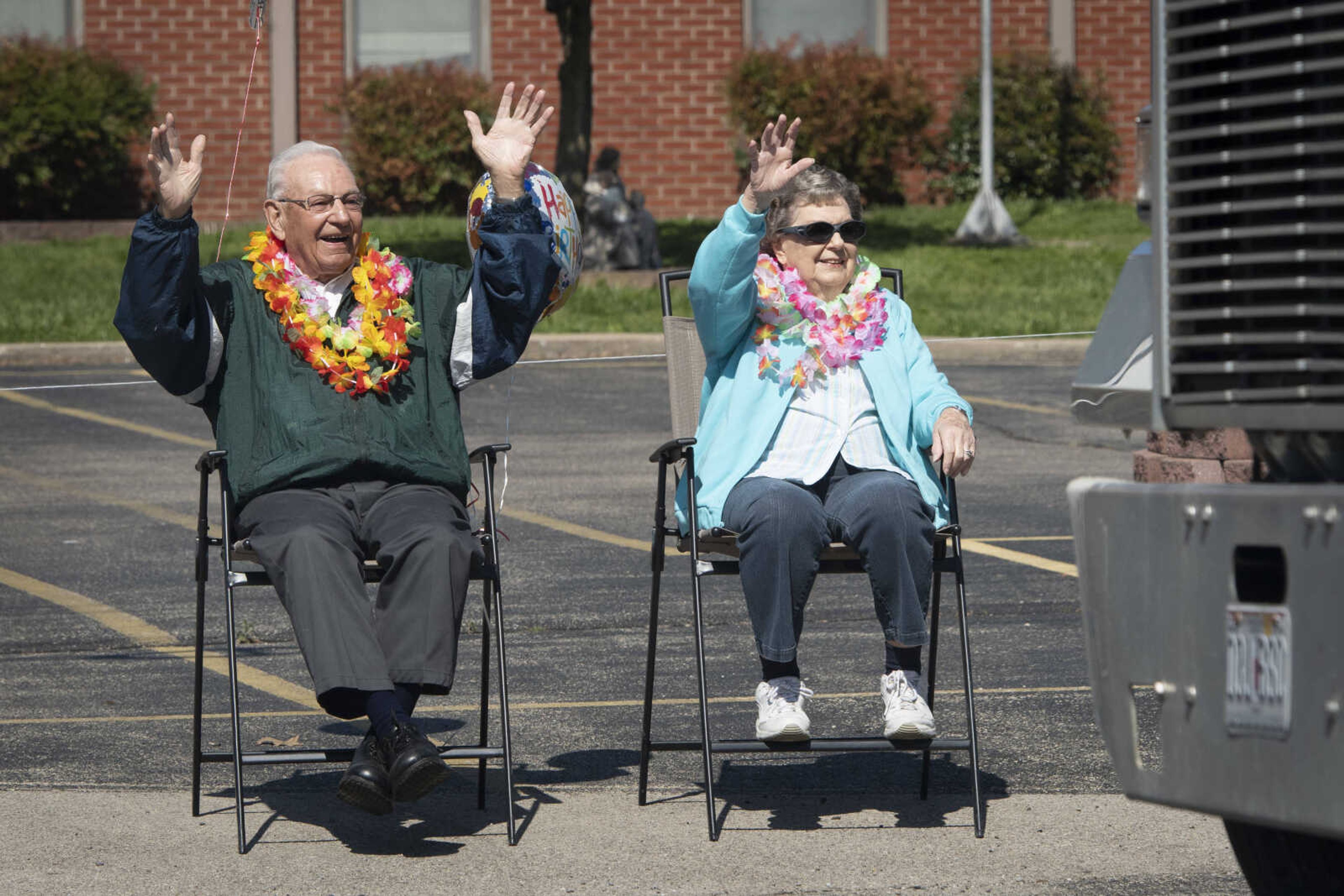 On his 90th birthday, Paul L. Essner of Benton, Missouri, and his wife Bert Essner wave to people passing in a parade celebrating Paul's birthday Saturday, April 18, 2020, outside St. Denis Catholic School in Benton, Missouri.