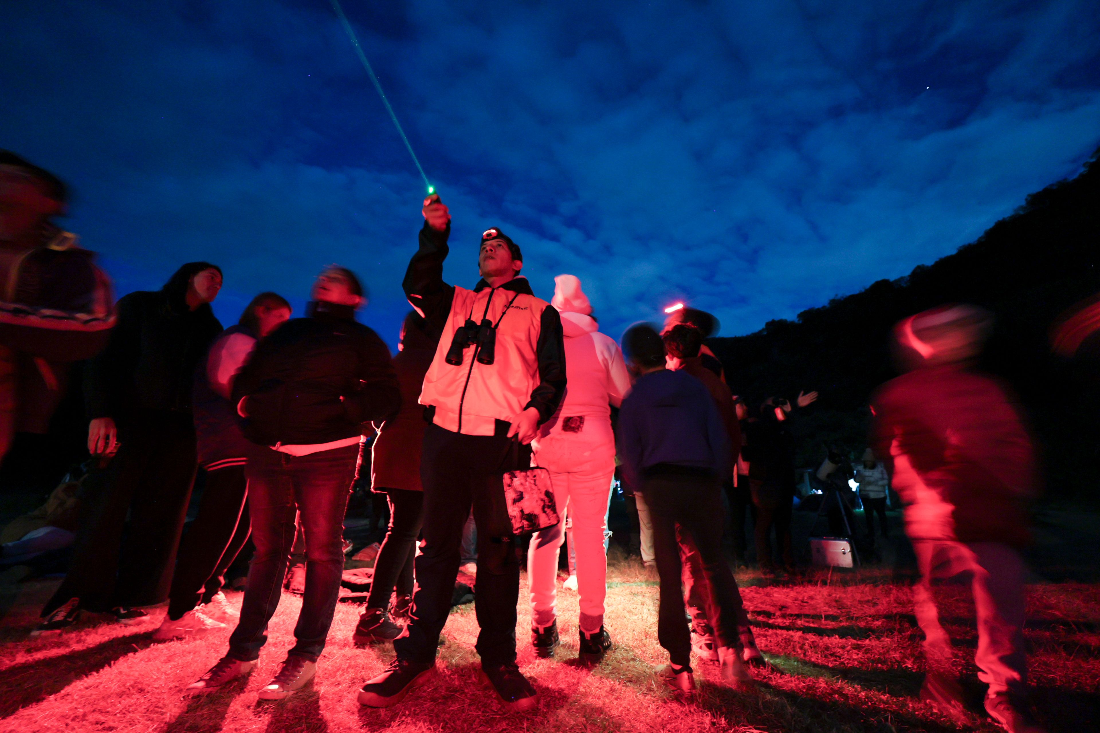 Ricardo Soriano, with a green laser, points at the sky during a stargazing and comet-watching gathering at Joya-La Barreta ecological park in Queretaro, Mexico, Saturday, Oct. 19, 2024. (AP Photo/Ginnette Riquelme)