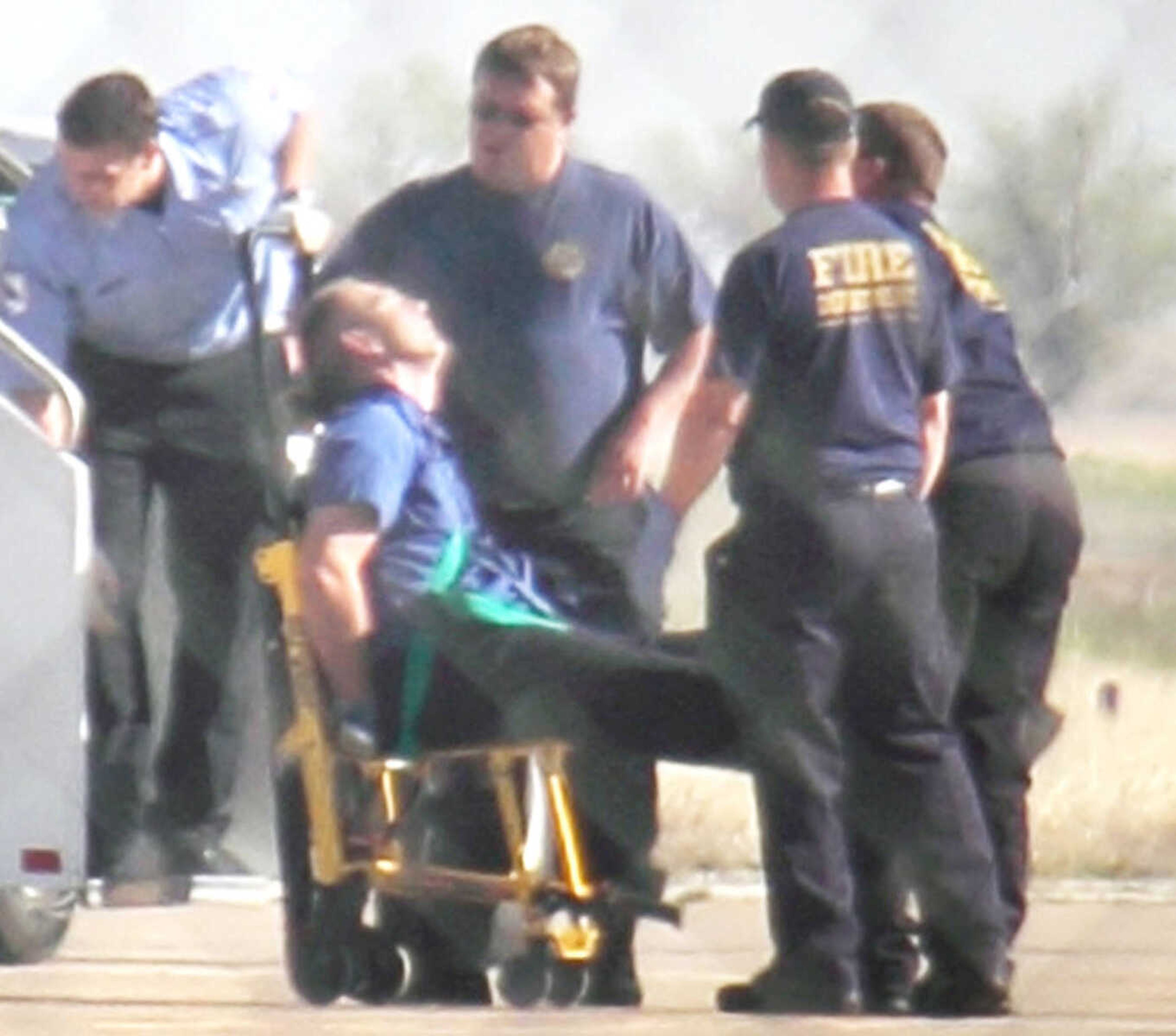 Emergency workers tend to a JetBlue captain that had a "medical situation" during a Las Vegas-bound flight from JFK International airport, Tuesday, March 27, 2012, in Amarillo, Texas. Passengers said the pilot screamed that Iraq or Afghanistan had planted a bomb on the flight, was locked out of the cockpit, and then tackled and restrained by passengers. The pilot who subsequently took command of the aircraft elected to land in Amarillo at about 10 a.m., JetBlue Airways said in a statement. (AP Photo/Steve Douglas)