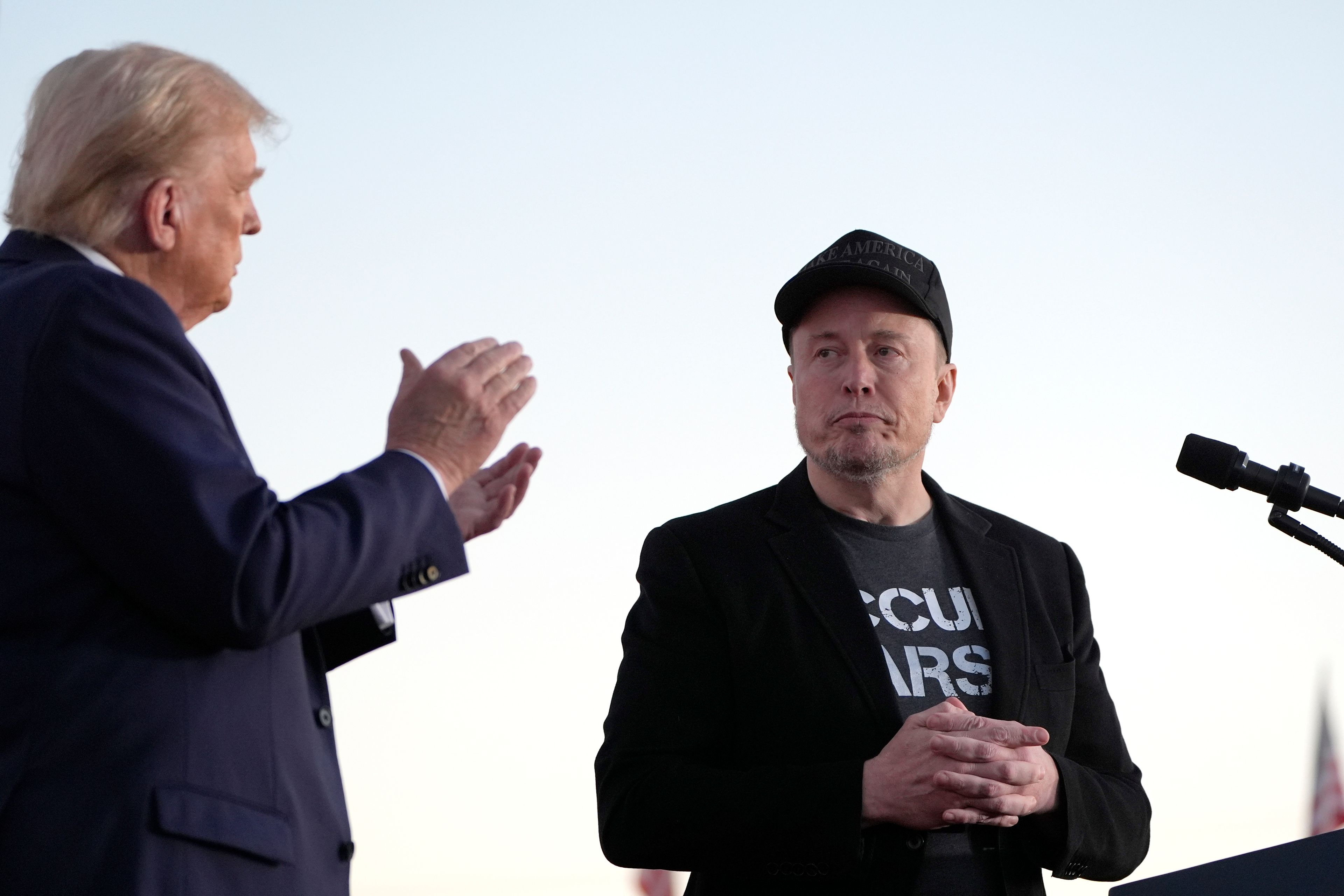 Republican presidential nominee former President Donald Trump, left, claps as Tesla and SpaceX CEO Elon Musk prepares to depart after speaking at a campaign event at the Butler Farm Show, Saturday, Oct. 5, 2024, in Butler, Pa. (AP Photo/Alex Brandon)