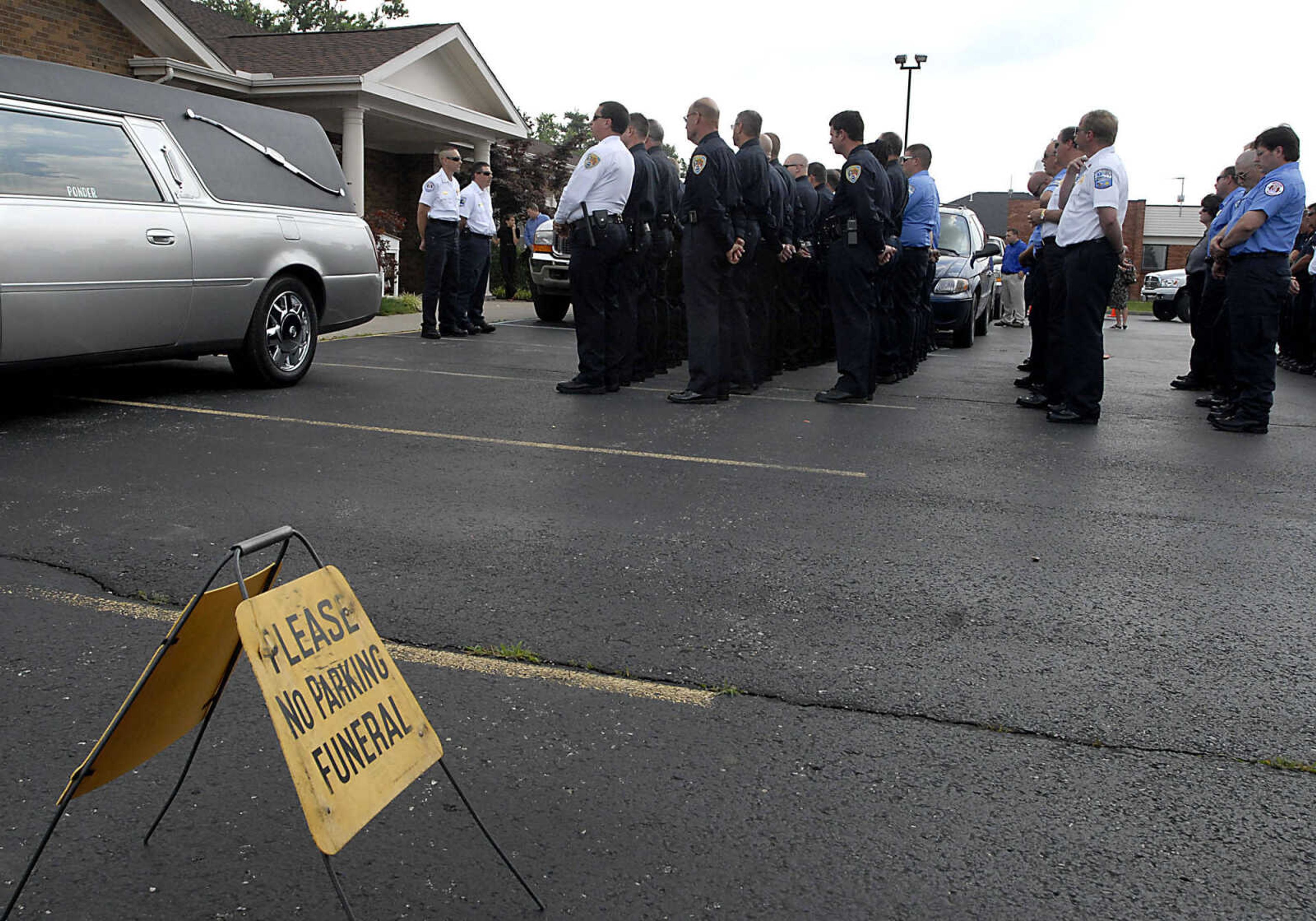 Emergency workers line up outside of Ponder Funeral Home following the funeral of Alexis Cummins Wednesday, June 3, 2009, in Sikeston.