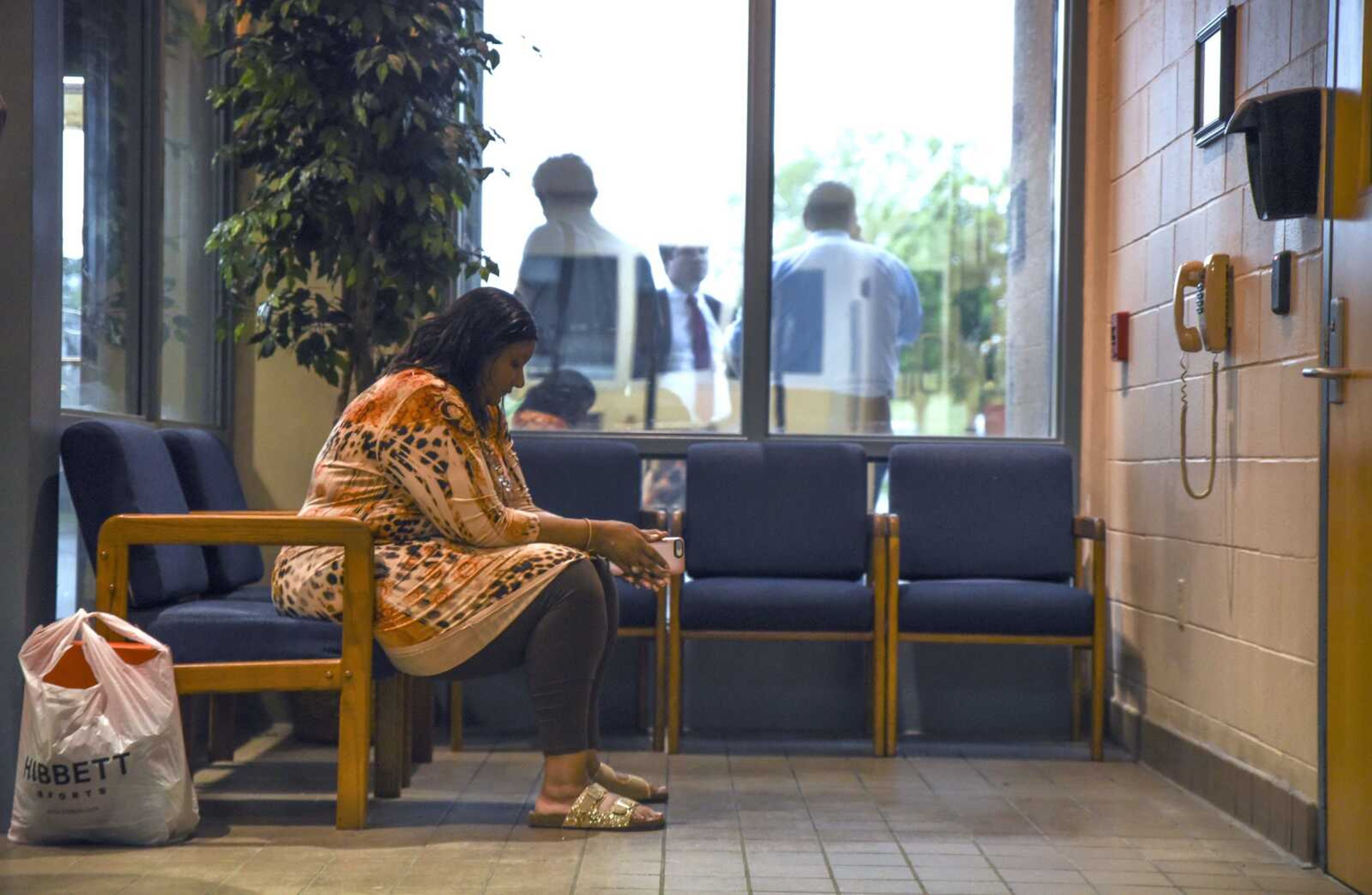 Pat Jackson, David Robinson's wife, sits in the waiting room of the Jefferson City Correctional Center while Robinson's attorneys speak amongst themselves outside the window Monday in Jefferson City, Missouri.