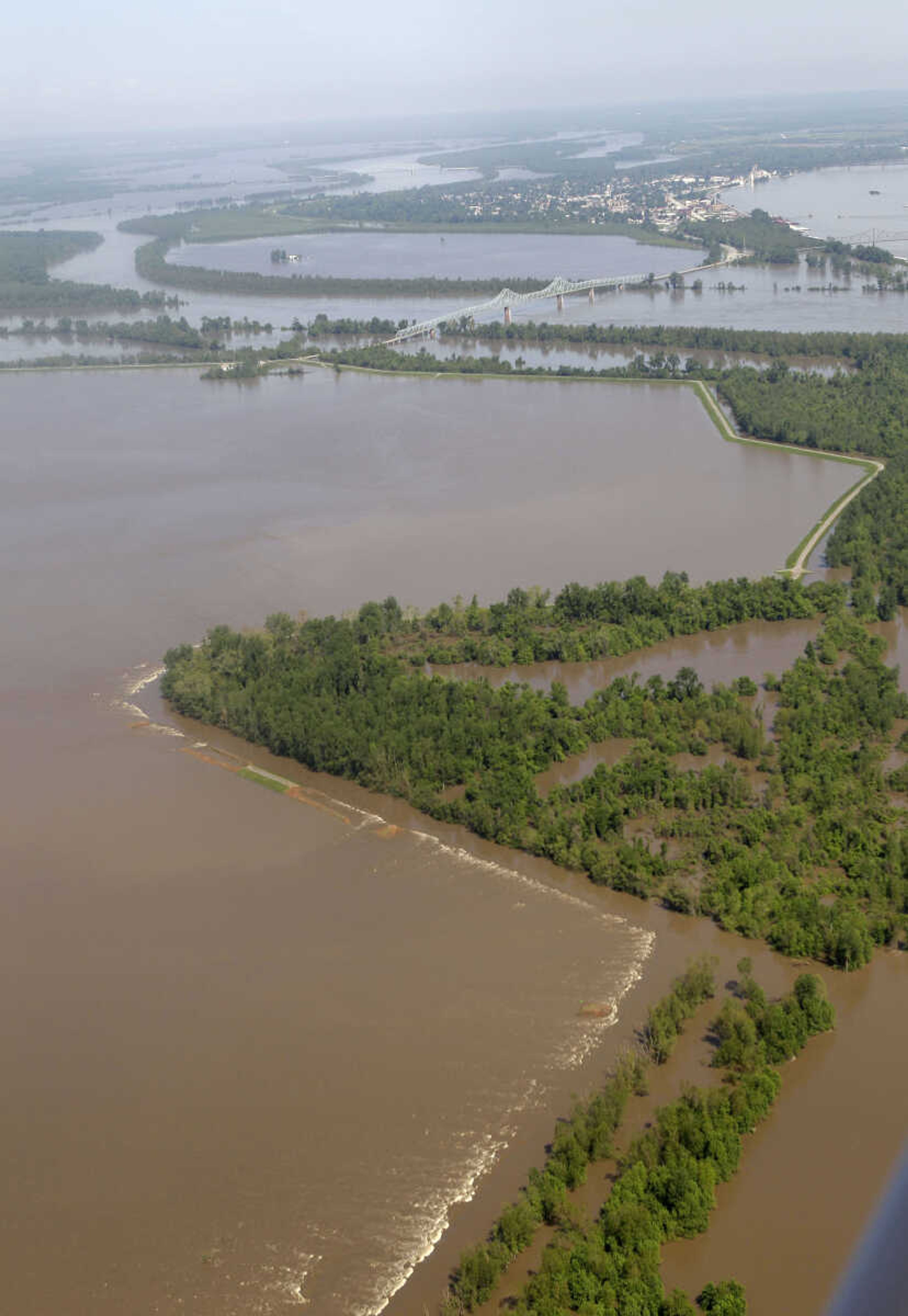 Flowing water creates white caps where a two-mile long section of the Birds Point levee stood (at bottom) as the town of Cairo, Ill., is seen at top right Tuesday, May 3, 2011, in Mississippi County, Mo.  The Army Corps of Engineers' blew a the hole into the Birds Point levee Monday night flooding 130,000 acres of farmland in Missouri's Mississippi County in an effort to protect nearby Cairo, Ill. and relieve flooding at the confluence of the Mississippi and Ohio rivers. (AP Photo/Jeff Roberson)