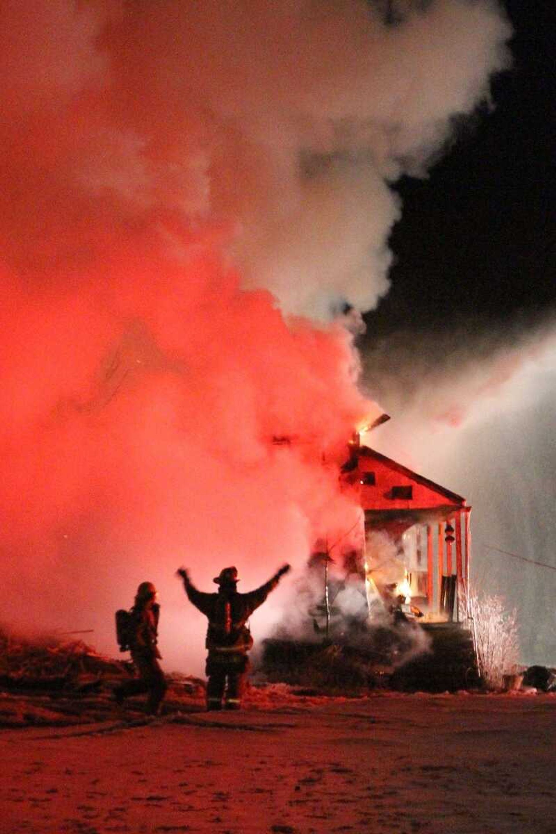 Firefighters signal to each other during a blaze that broke out in a home at 649 Jackson Road in Pocahontas on Friday night. (Glenn Landberg)