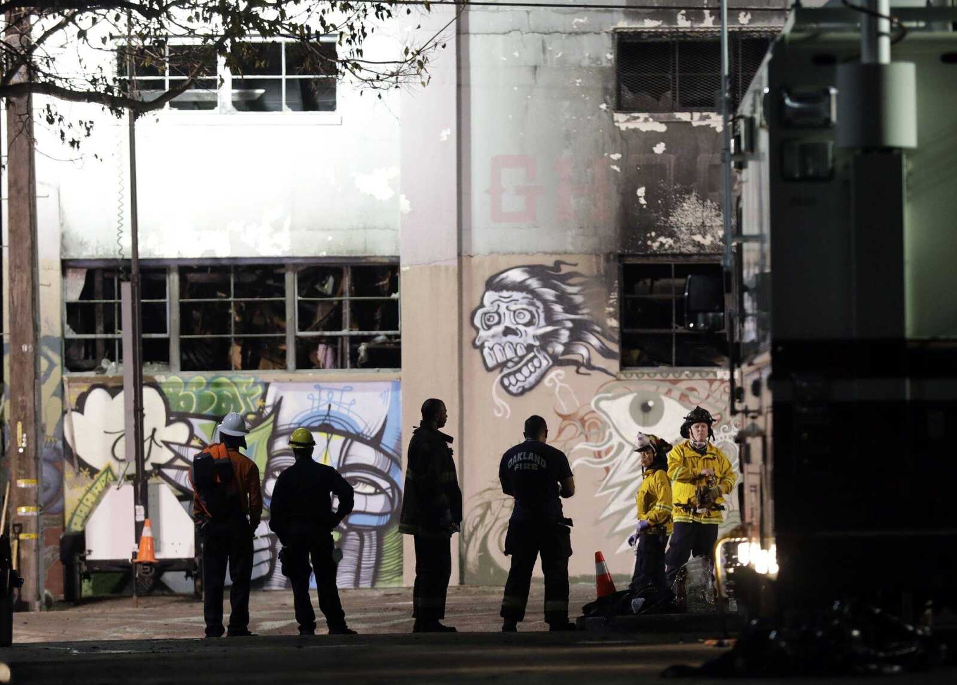 Emergency personnel stage Sunday in front of the site of a warehouse fire that started Friday night and killed dozens in Oakland, California.