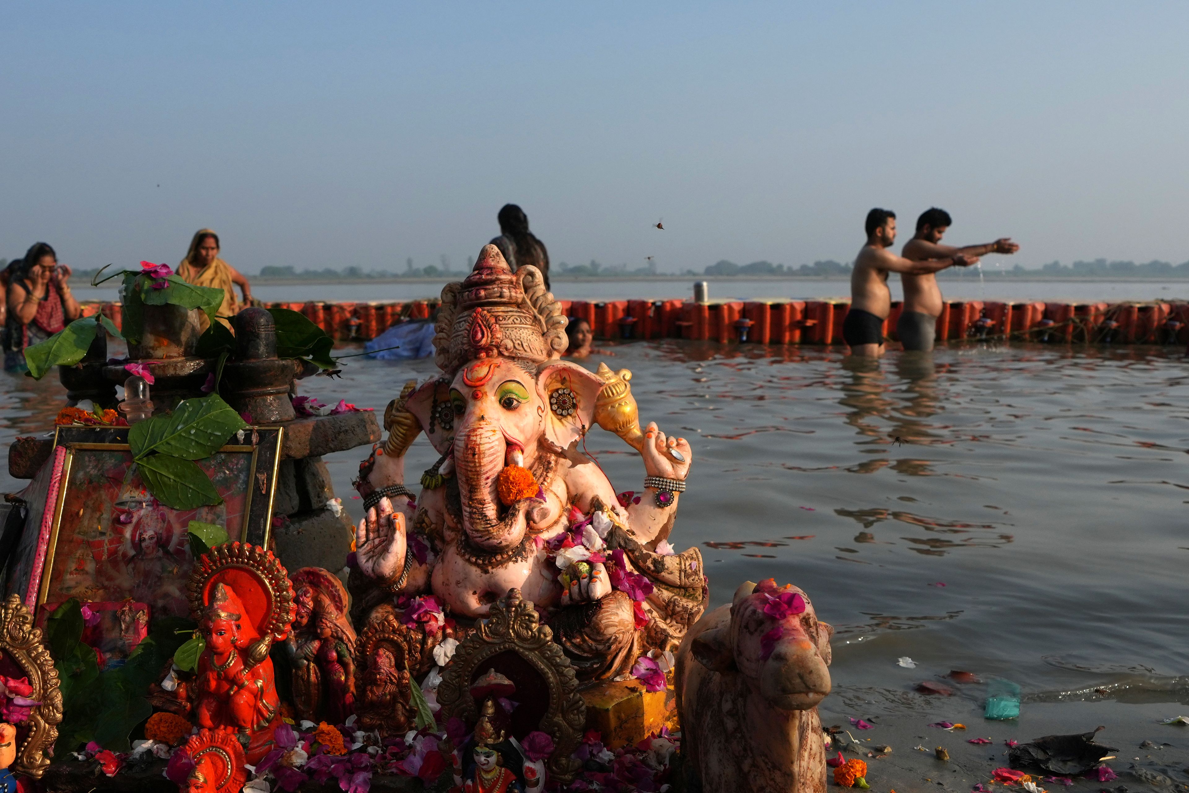 Idols of Hindu god Ganesha and other deities are adorned with offerings as devotees take a holy dip in the Saryu river on the morning before Deepotsav celebrations, an event organized by the Uttar Pradesh state government on the eve of Diwali, in Ayodhya, India, Tuesday, Oct. 29, 2024. (AP Photo/Rajesh Kumar Singh)