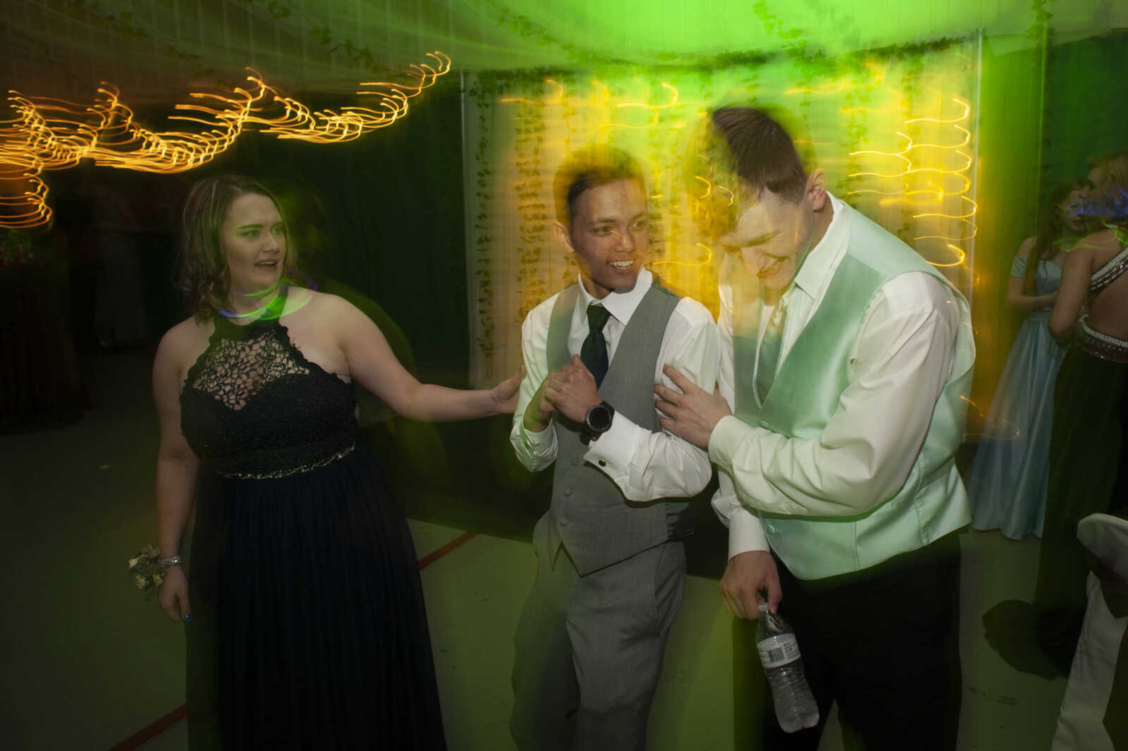 Delta seniors Dezi Tanner, left, and Cameron Pagel, middle, take to the dance floor next to Delta junior Jon Bond during Delta High School's prom on Saturday, April 13, 2019, at the Delta Community Center.