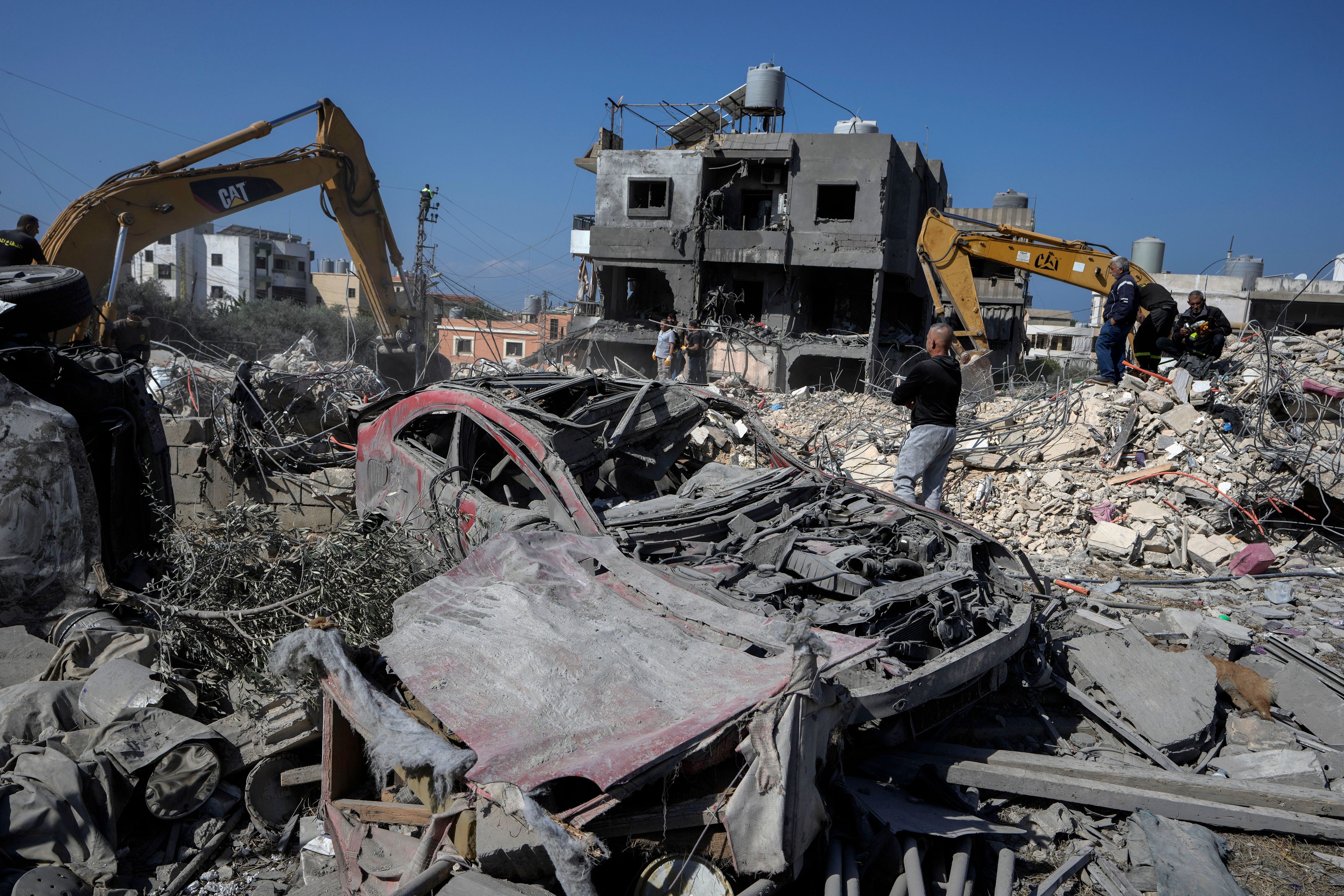 Rescue workers use excavators to remove the rubble of a destroyed building that was hit Tuesday night in an Israeli airstrike, as they search for victims in Sarafand, south Lebanon, Wednesday, Oct. 30, 2024. (AP Photo/Bilal Hussein)