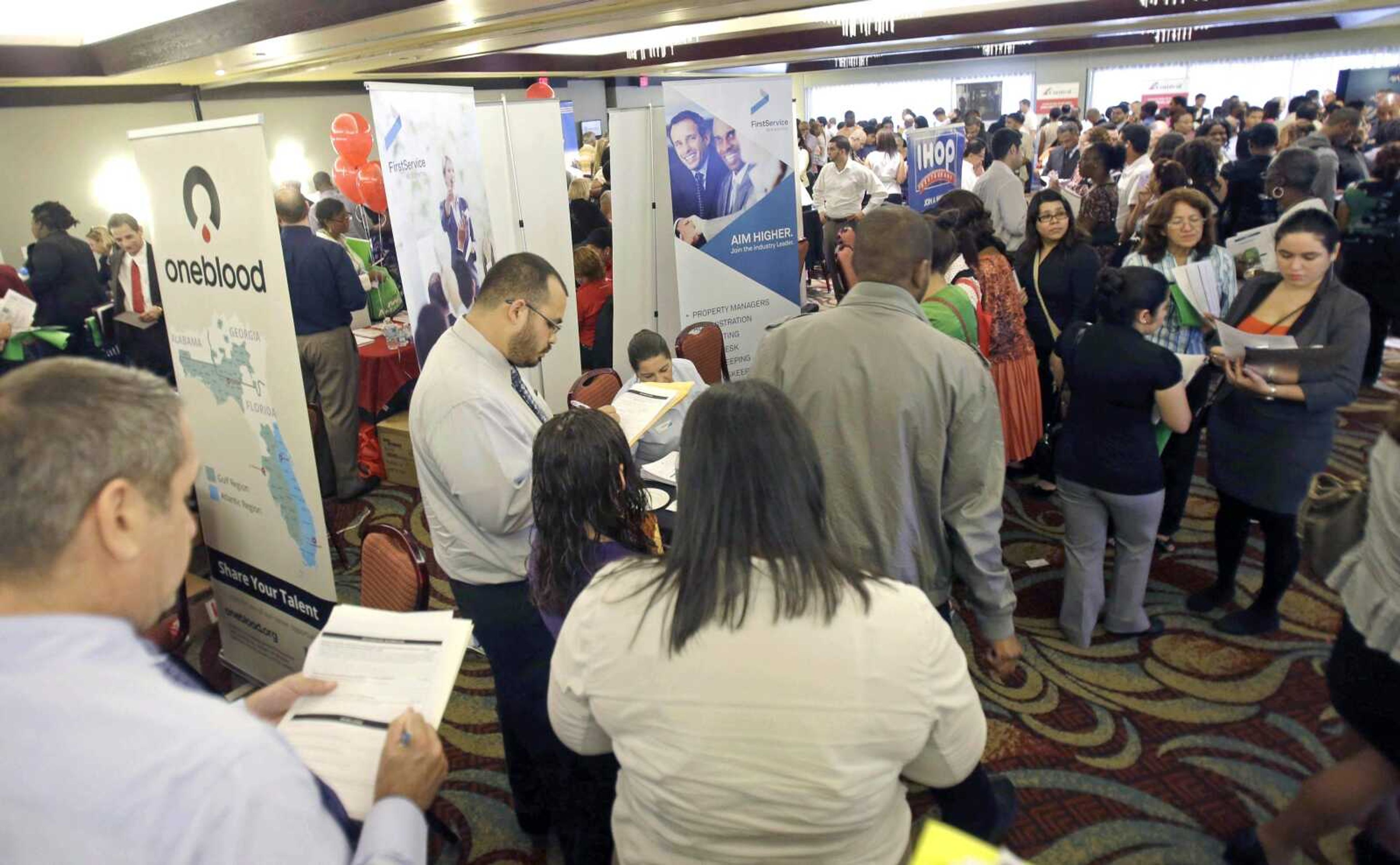 Job seekers check out companies at a job fair Aug. 14 in Miami Lakes, Fla. Analysts predict that employers added 177,000 jobs in August. (Alan Diaz ~ Associated Press)