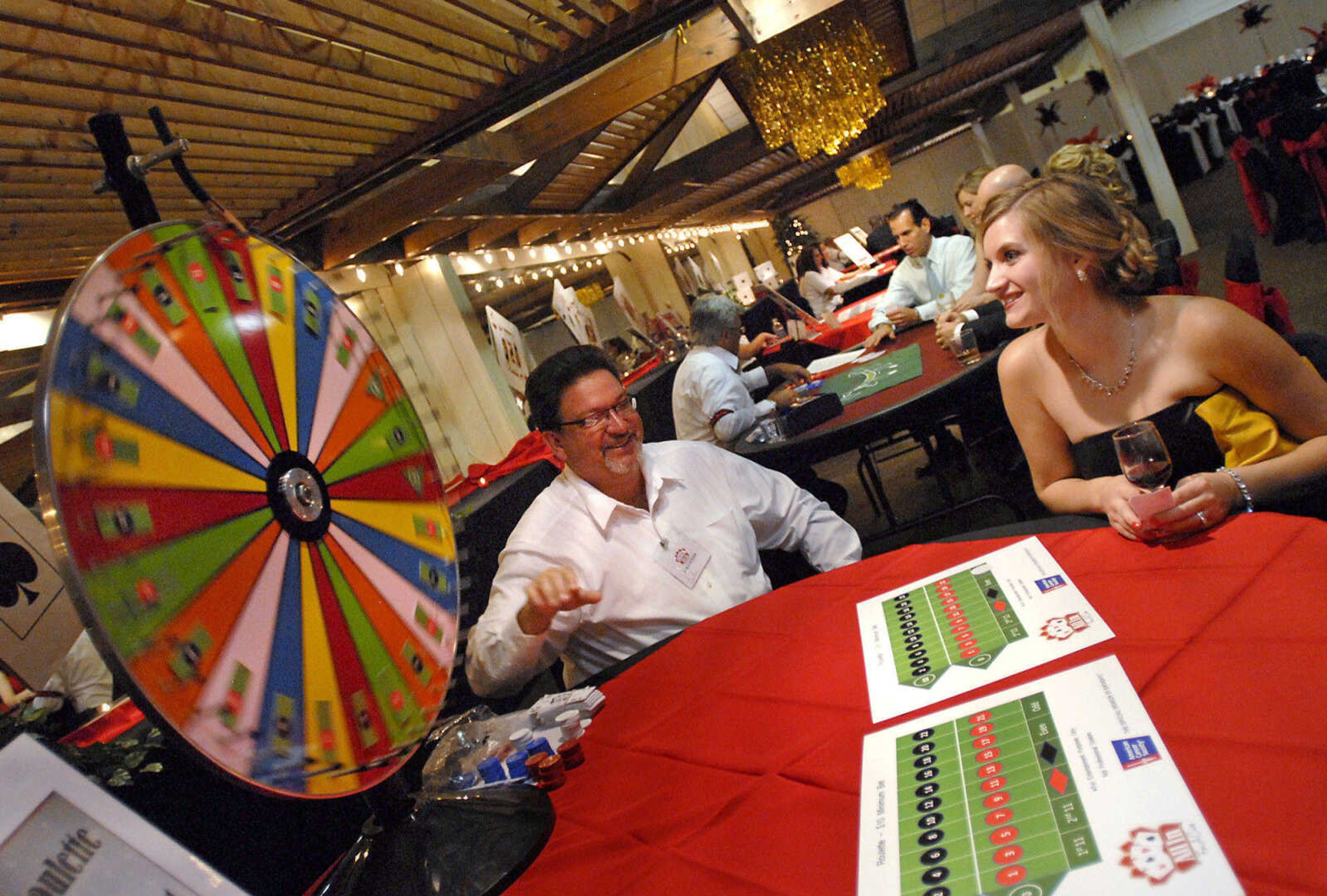 KRISTIN EBERTS ~ keberts@semissourian.com

Leslie Hazelwood watches as Galen Sanders spins the roulette wheel as she plays a round during the annual American Cancer Society Gala on Saturday, Aug. 27, 2011, at Ray's Plaza Conference Center in Cape Girardeau. This year's theme was "All-In For a Cure. "