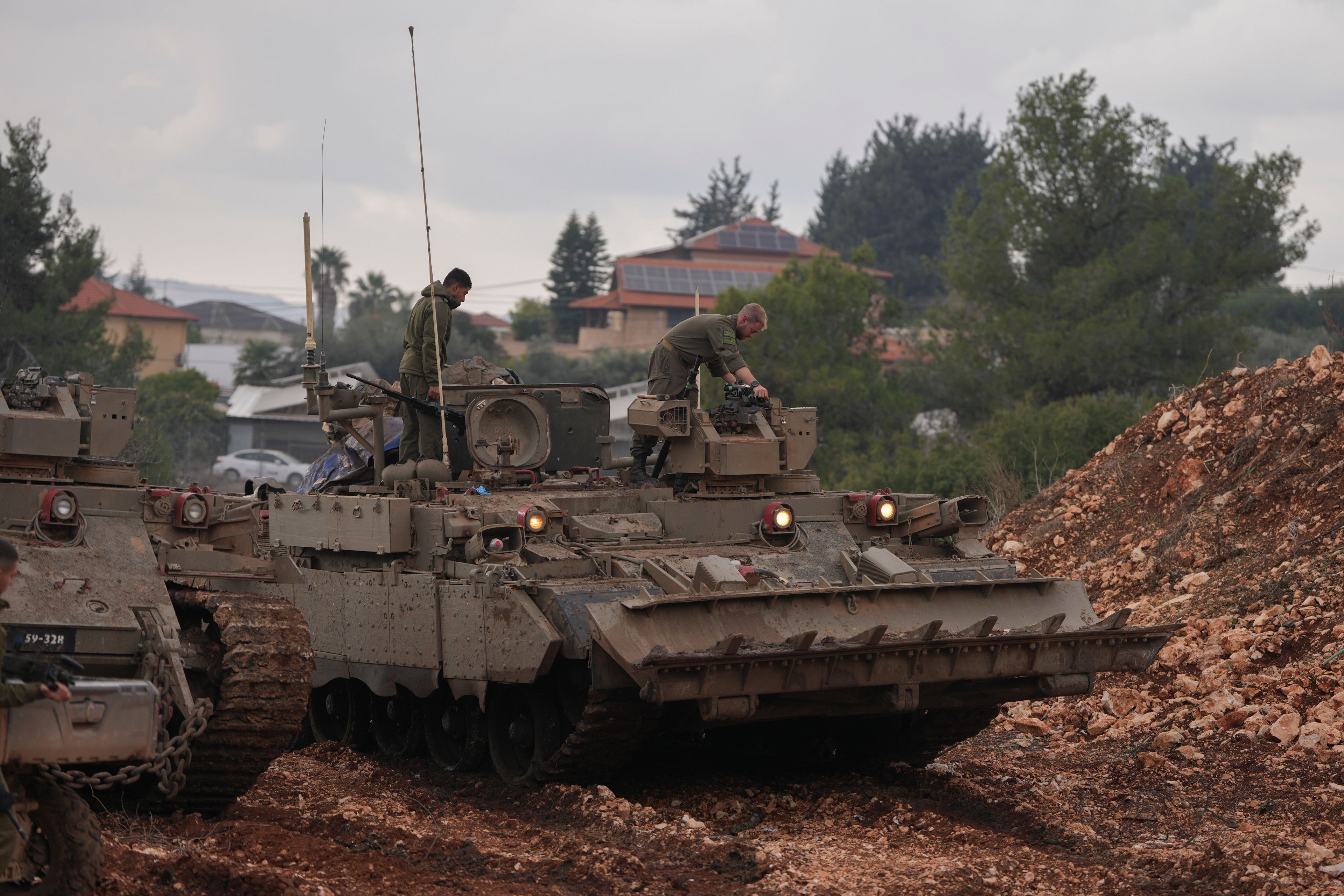 Israeli soldiers stand atop army armoured vehicles outside the agricultural settlement of Avivim, next to the Lebanese border in upper Galilee, Israel, Thursday Nov 28, 2024. (AP Photo/Ohad Zwigenberg)