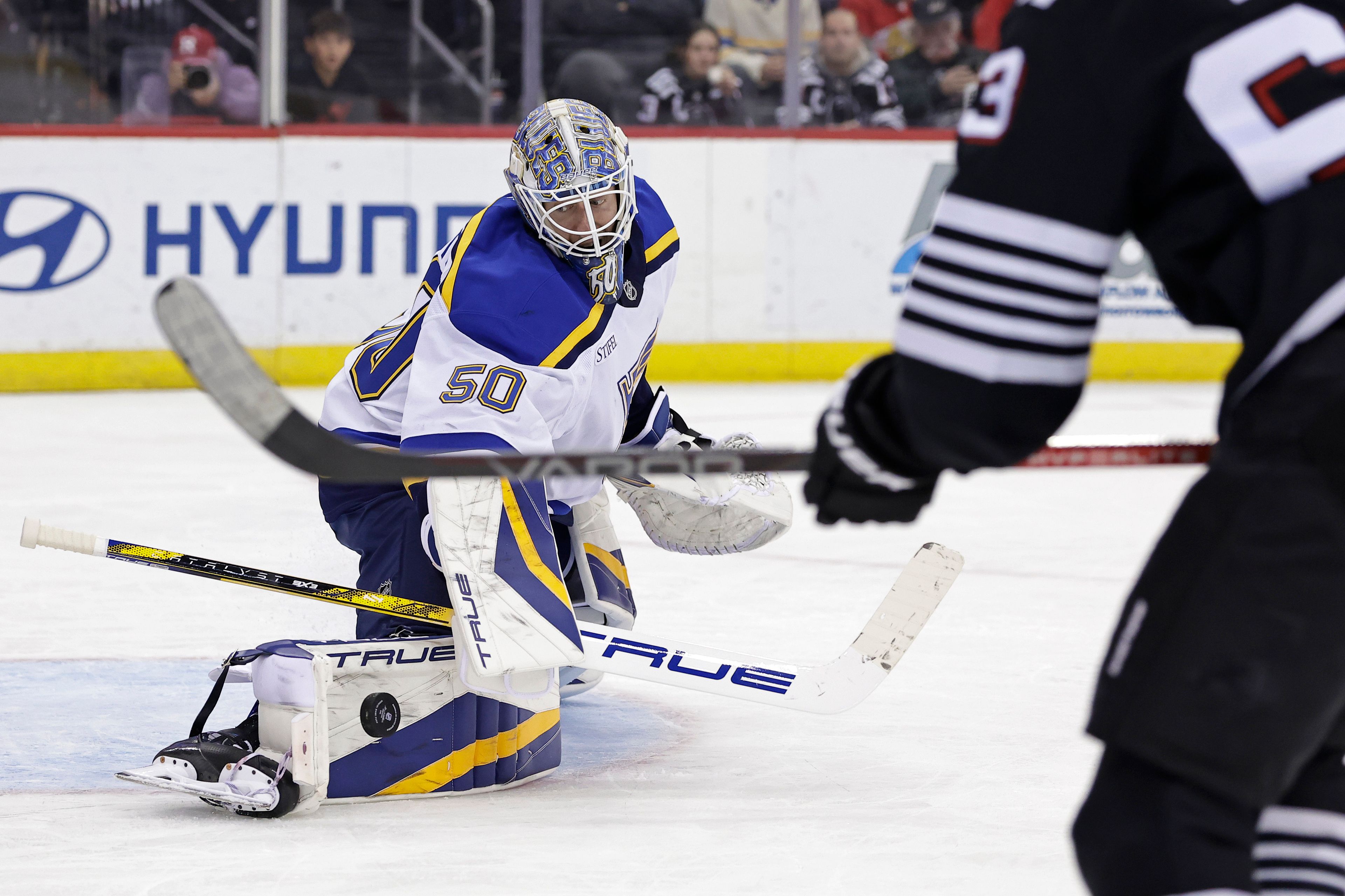 St. Louis Blues goaltender Jordan Binnington makes a save in front of New Jersey Devils left wing Jesper Bratt during the second period of an NHL hockey game Wednesday, Nov. 27, 2024, in Newark, N.J. (AP Photo/Adam Hunger)