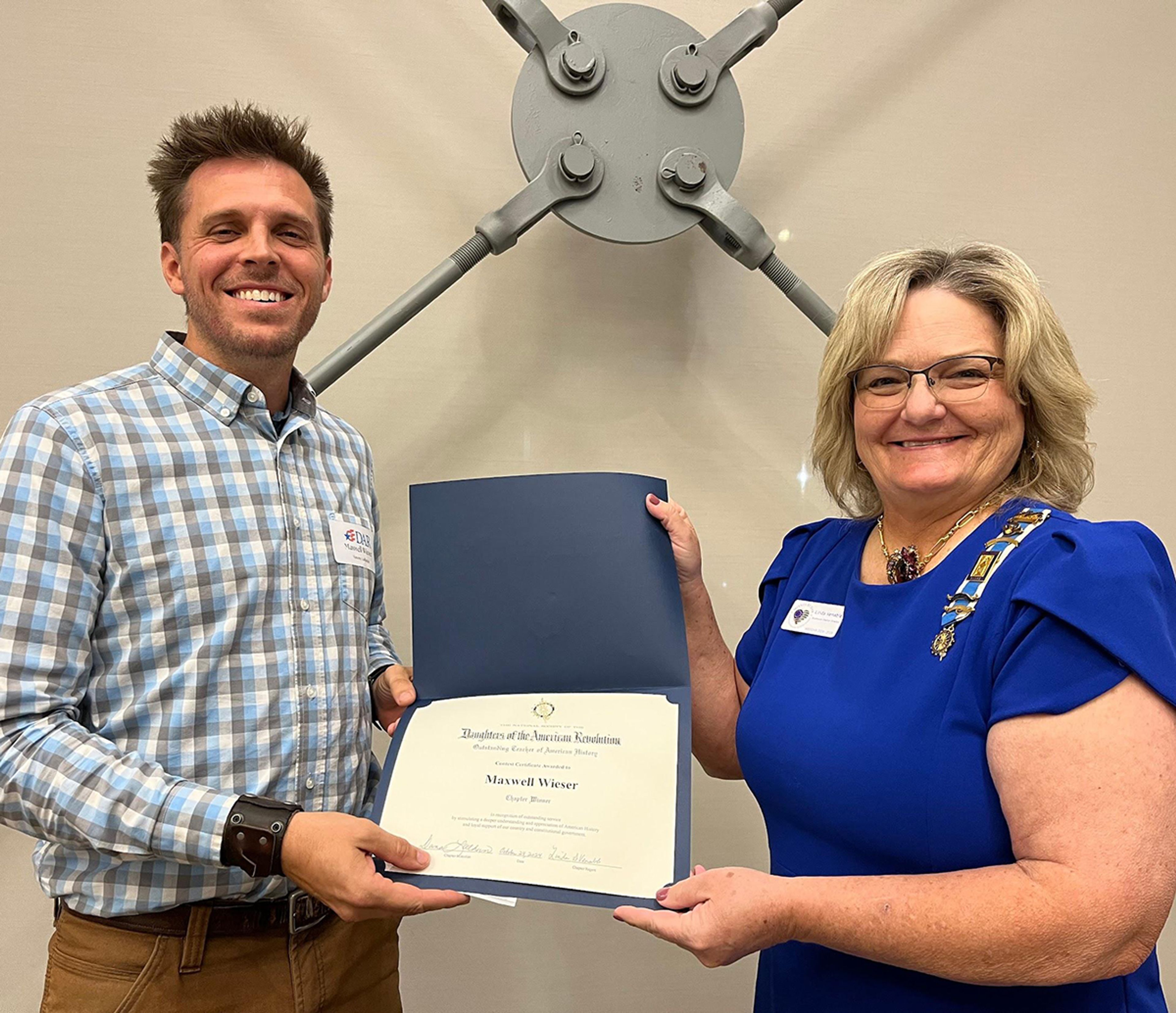 John Guild Chapter Outstanding Teacher of American History 2024 Maxwell Wieser of Saxony Lutheran and Chapter Regent Linda Venable.