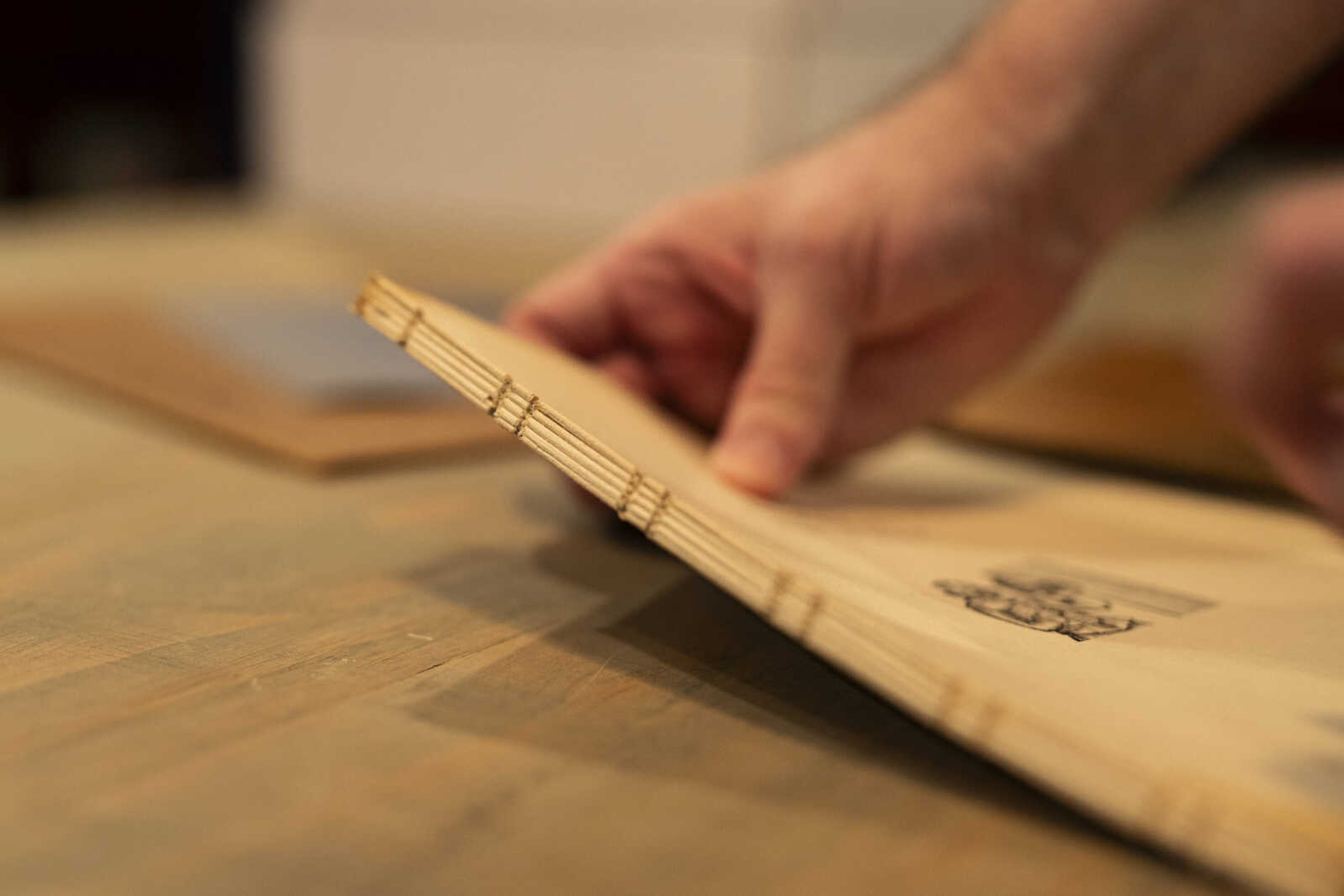 Gary Howard, Jr. holds up the edge of a book he is in the process of restoring. Howard reconnected with his mentor, fellow magician and book restorer Leo Behnke, approximately seven years ago and soon after learned how to restore books. 