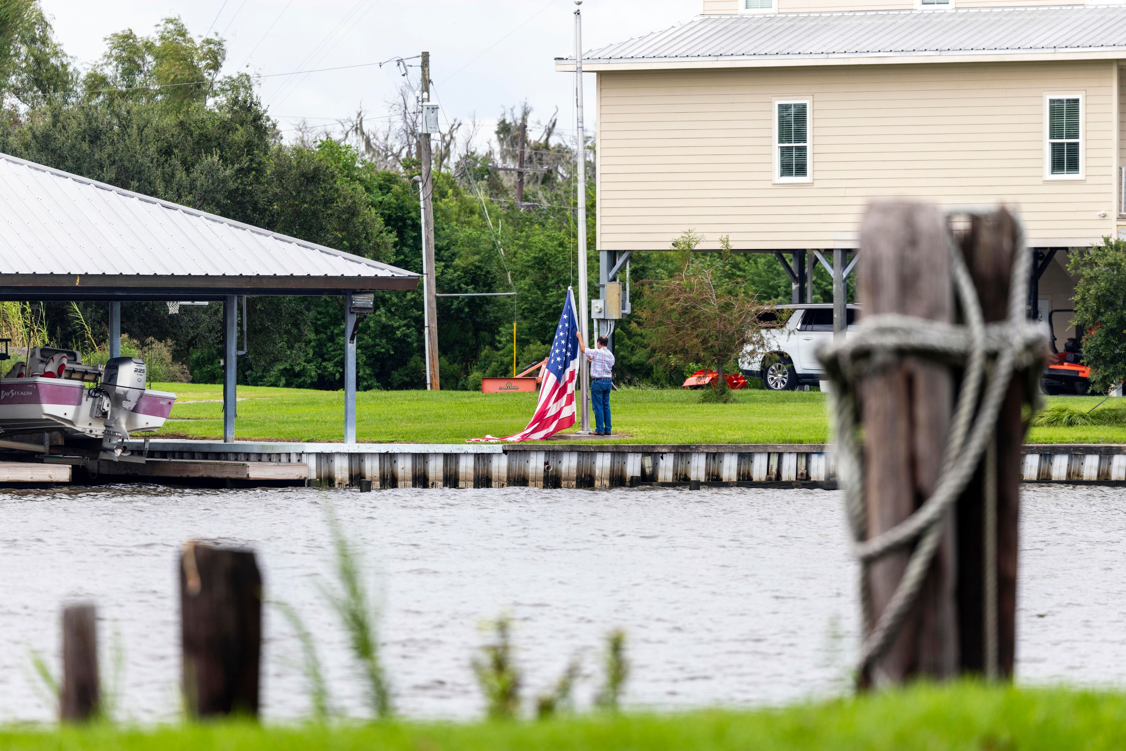 An flag is taken down off a pole as residents prepare for the arrival of Hurricane Francine along the Louisiana coast on Monday, Sept. 9, 2024, in Lafitte, La. (Chris Granger/The Times-Picayune/The New Orleans Advocate via AP)