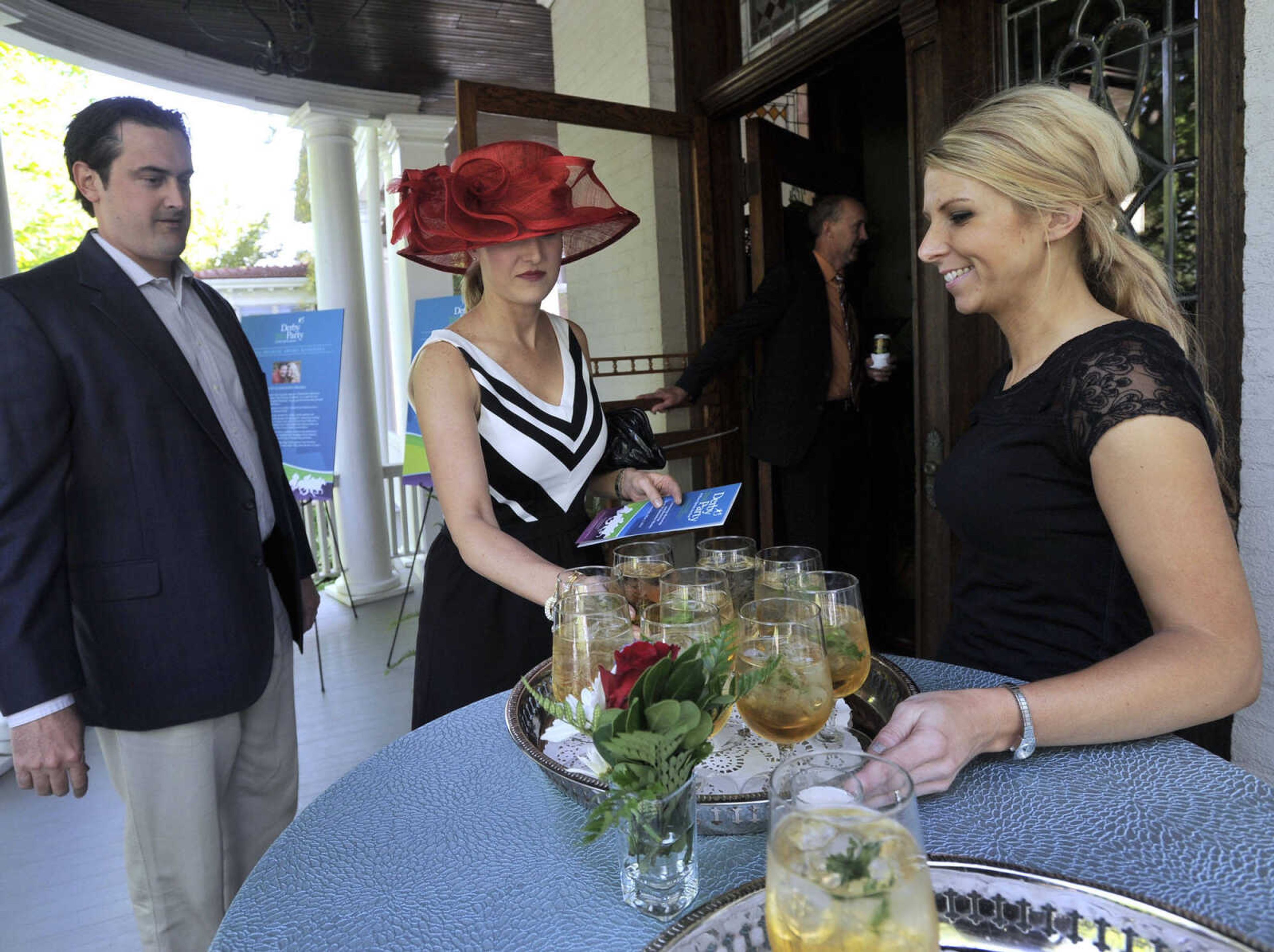 FRED LYNCH ~ flynch@semissourian.com
Katie Britt, right, serves mint juleps to Jim and Maria Childress at the Derby Party sponsored by Big Brothers Big Sisters of Eastern Missouri on Saturday, May 3, 2014 at the Glenn House in Cape Girardeau.