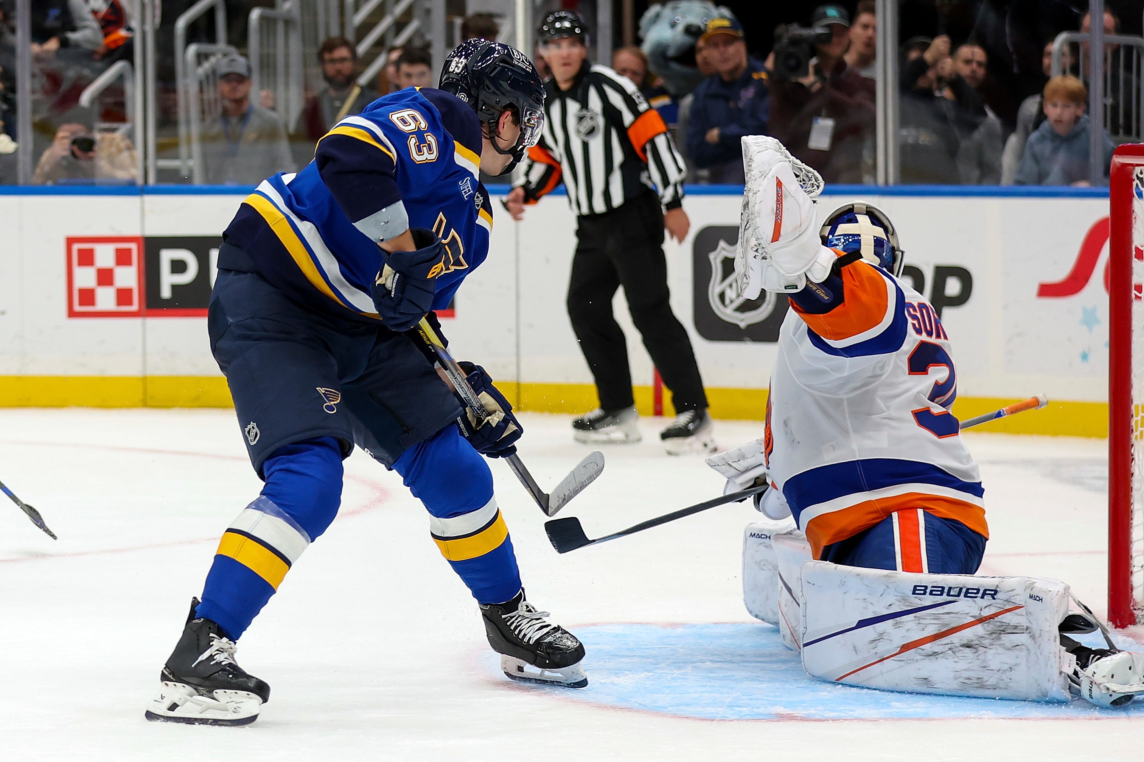 St. Louis Blues' Jake Neighbours (63) scores a goal against New York Islanders goaltender Ilya Sorokin (30) during the overtime period of an NHL hockey game Thursday, Oct. 17, 2024, in St. Louis. (AP Photo/Scott Kane)