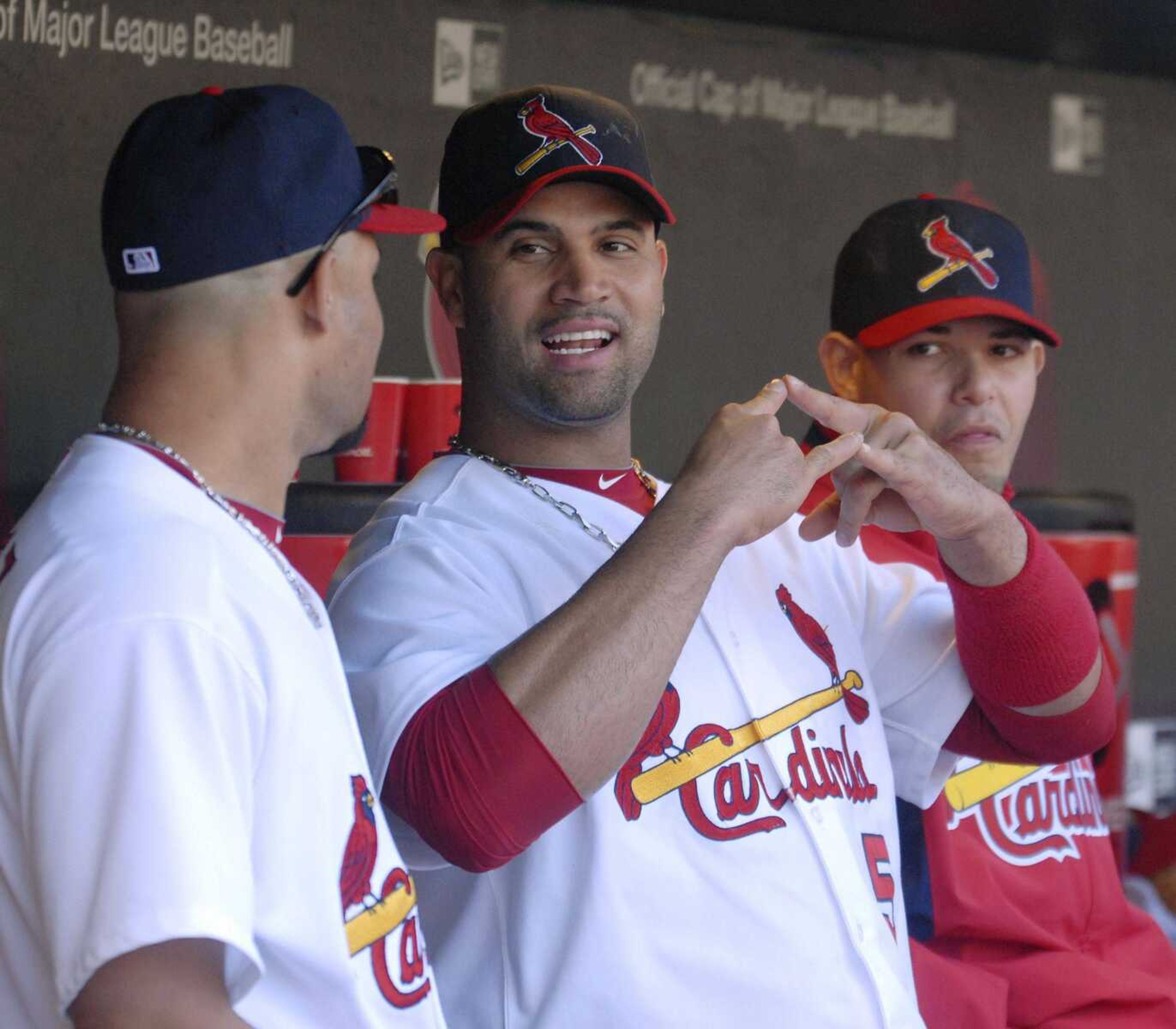 Cardinals first baseman Albert Pujols talks with teammates Pedro Feliz, left, and Yadier Molina after being removed from Sunday's season-ending game against the Rockies during the sixth inning. Pujols, a three-time NL MVP, led the National League with 118 RBIs and 42 home runs. (Bill Boyce ~ Associated Press)