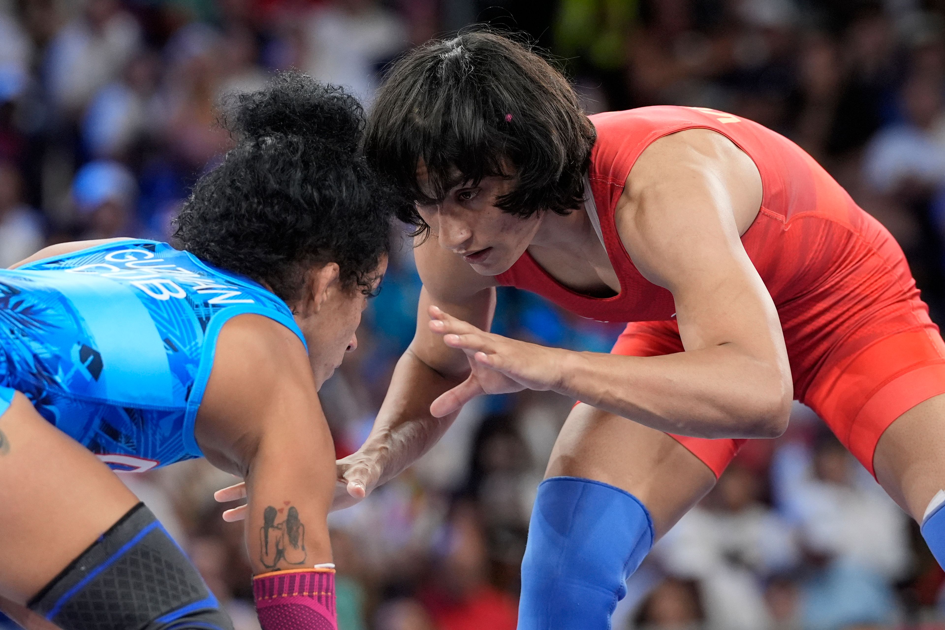 CORRECTS NAME TO VINESH PHOGAT, NOT VINESH VINESH - India's Vinesh Phogat and Cuba's Yusneylys Guzman, right, compete during their women's freestyle 50kg wrestling semifinal match, at Champ-de-Mars Arena, during the 2024 Summer Olympics, Tuesday, Aug. 6, 2024, in Paris, France. (AP Photo/Eugene Hoshiko)