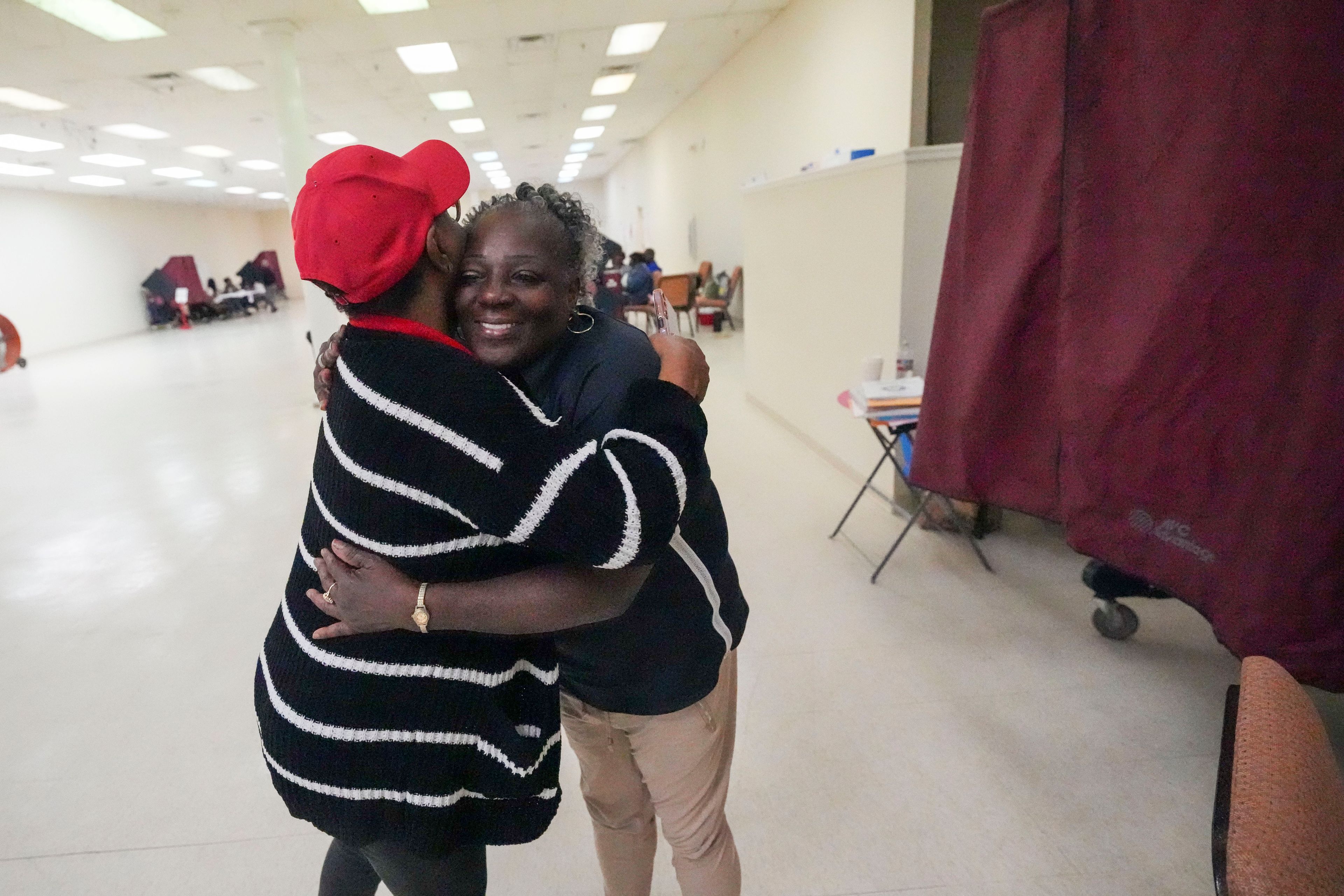 Precinct commissioner Lula Joseph, left, hugs Deneen Surtain after she cast her vote at the Household of Faith Church in New Orleans on Election Day, Tuesday, Nov. 5, 2024. (AP Photo/Gerald Herbert)