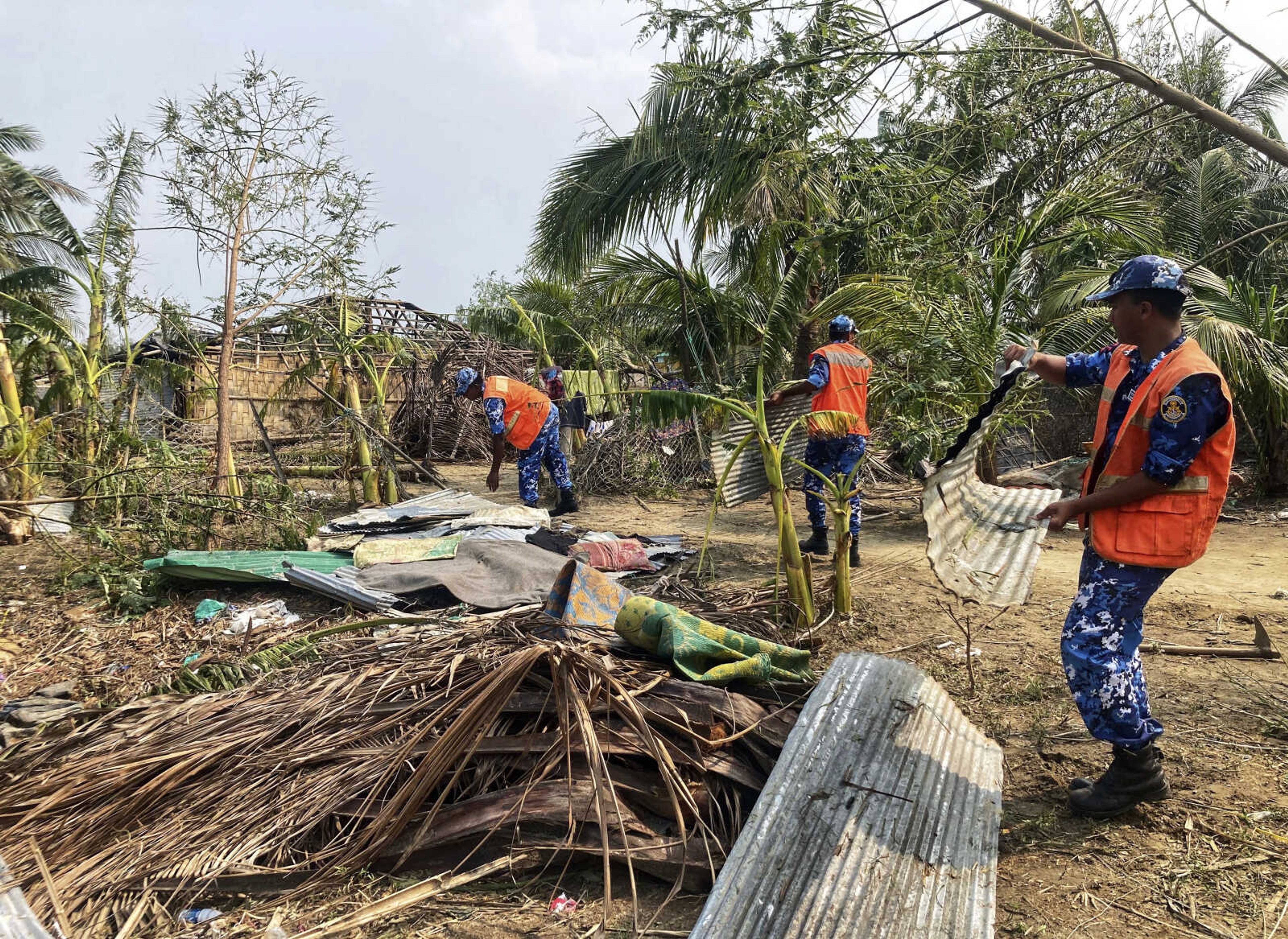 Coast guard soldiers Monday survey the damage caused by Cyclone Mocha at Saint Martin island in Cox's Bazar, Bangladesh. Mocha largely spared the Bangladeshi city of Cox's Bazar, which initially had been in the storm's predicted path. Authorities had evacuated hundreds of thousands of people before the cyclone veered east.