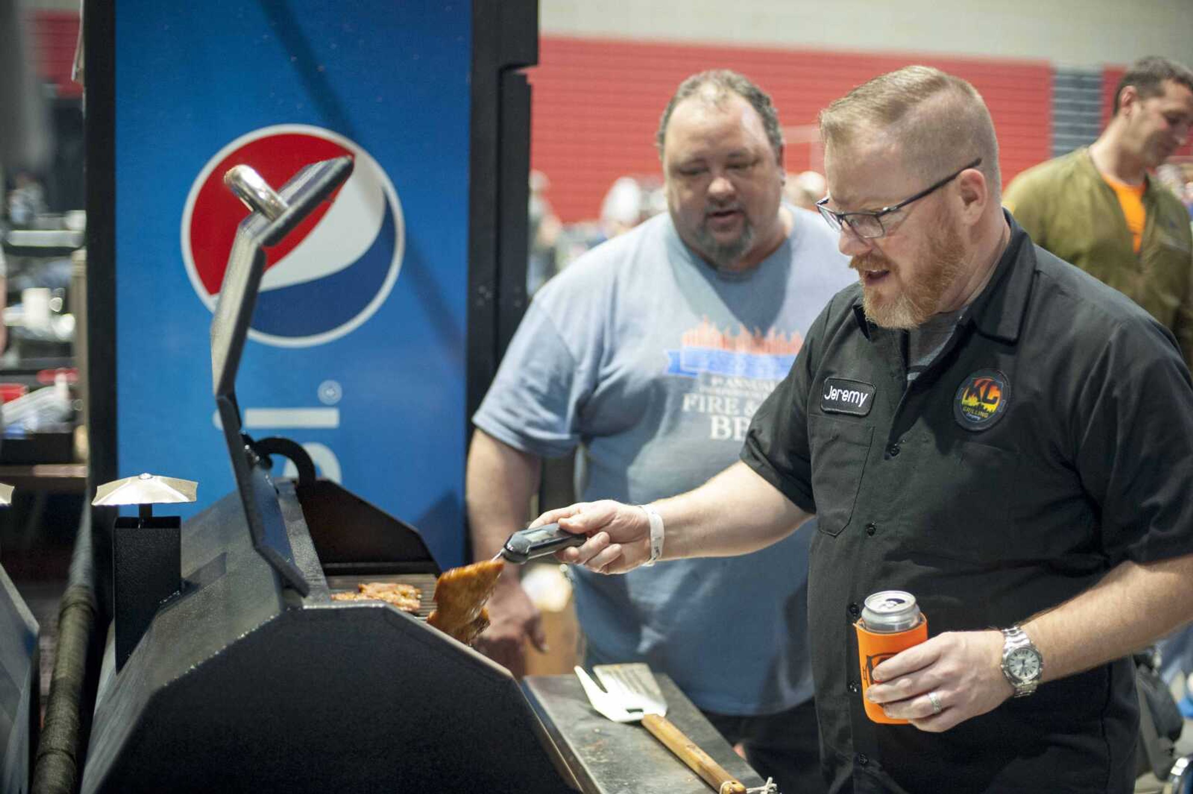 Jeremy Williams, right, and Phil Hood monitor a grill during the "When Pigs Fly" indoor BBQ bash Saturday, Jan. 25, 2020, at the Show Me Center in Cape Girardeau.