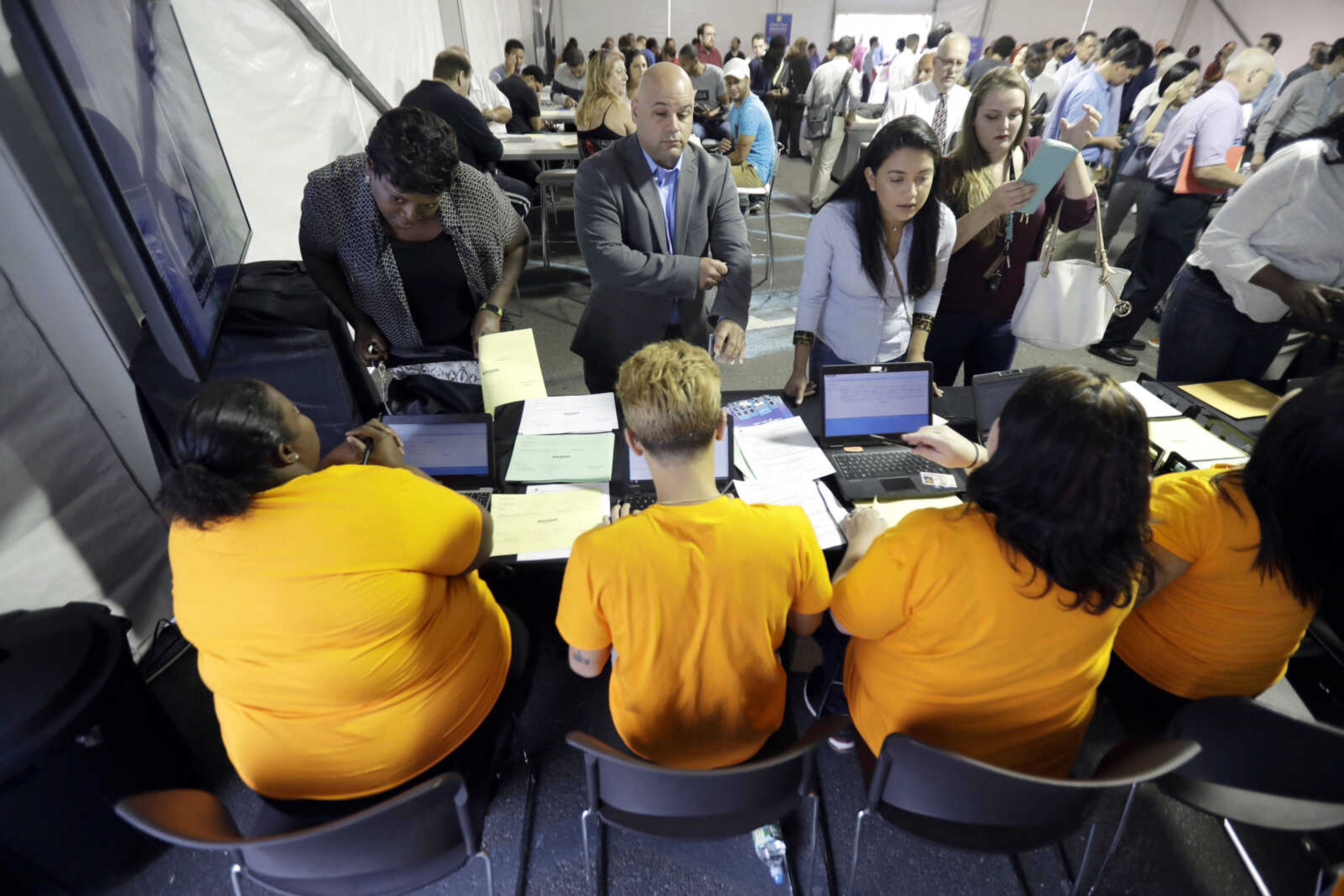 Job candidates are processed during a job fair at the Amazon fulfillment center Aug. 2 in Robbinsville Township, New Jersey.