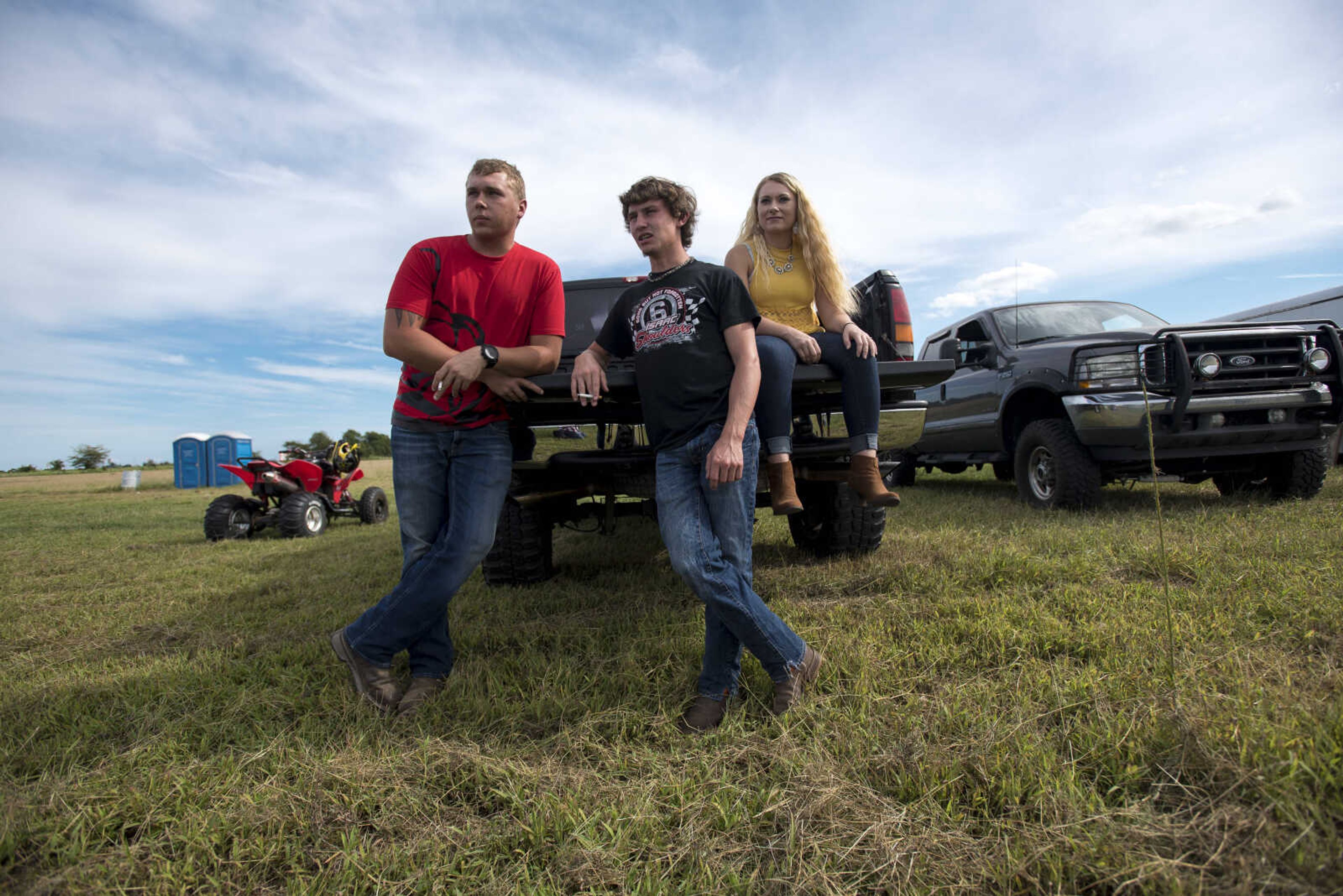 From left, Clint Sunderland, Justin Ware and Kayla Benham watch as races drag during their trial runs at the Missouri Dirt Motorsports Saturday, August 12, 2017 in Sikeston.