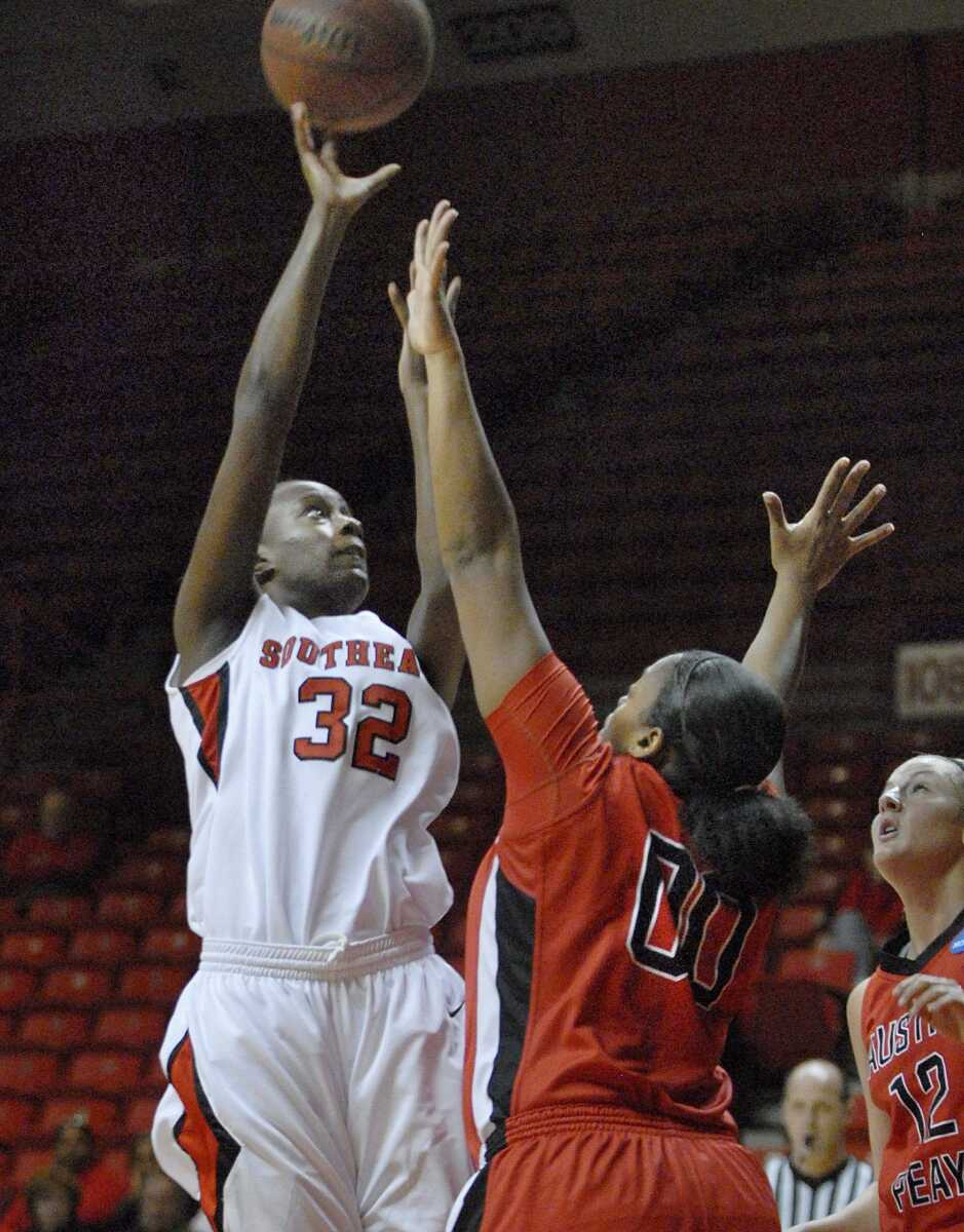 Southeast Missouri State's Patricia Mack puts up a shot over Austin Peay's Jasmine Rayner and Whitney Hanley, right, during the first half Monday at the Show Me Center. Southeast won 69-60. (Kristin Eberts)