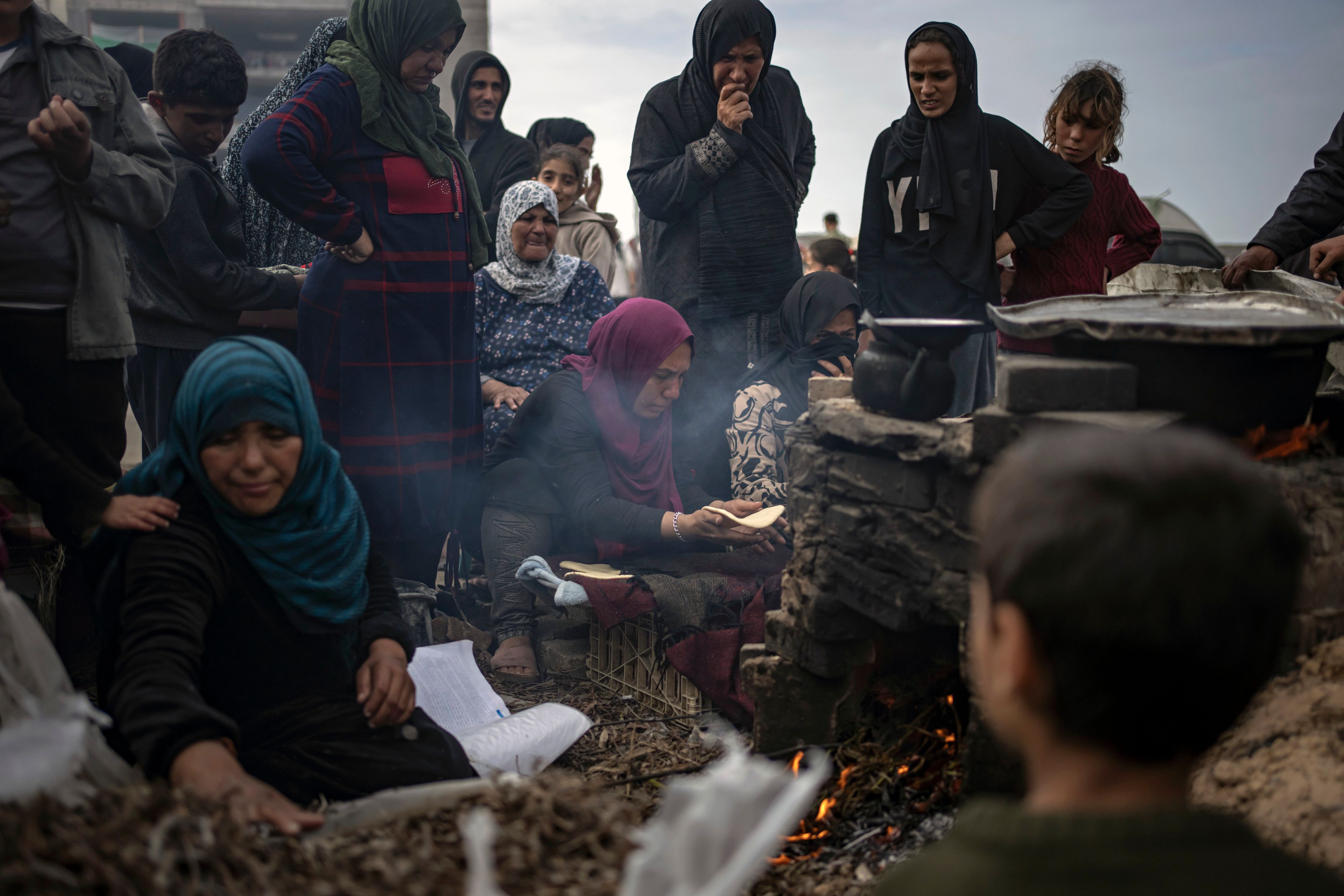 FILE - Palestinians displaced by the Israeli bombardment wait for their turn to bake bread at the makeshift tent camp in the Muwasi area in Rafah, Gaza Strip, Saturday, Dec. 23, 2023. (AP Photo/Fatima Shbair, File)