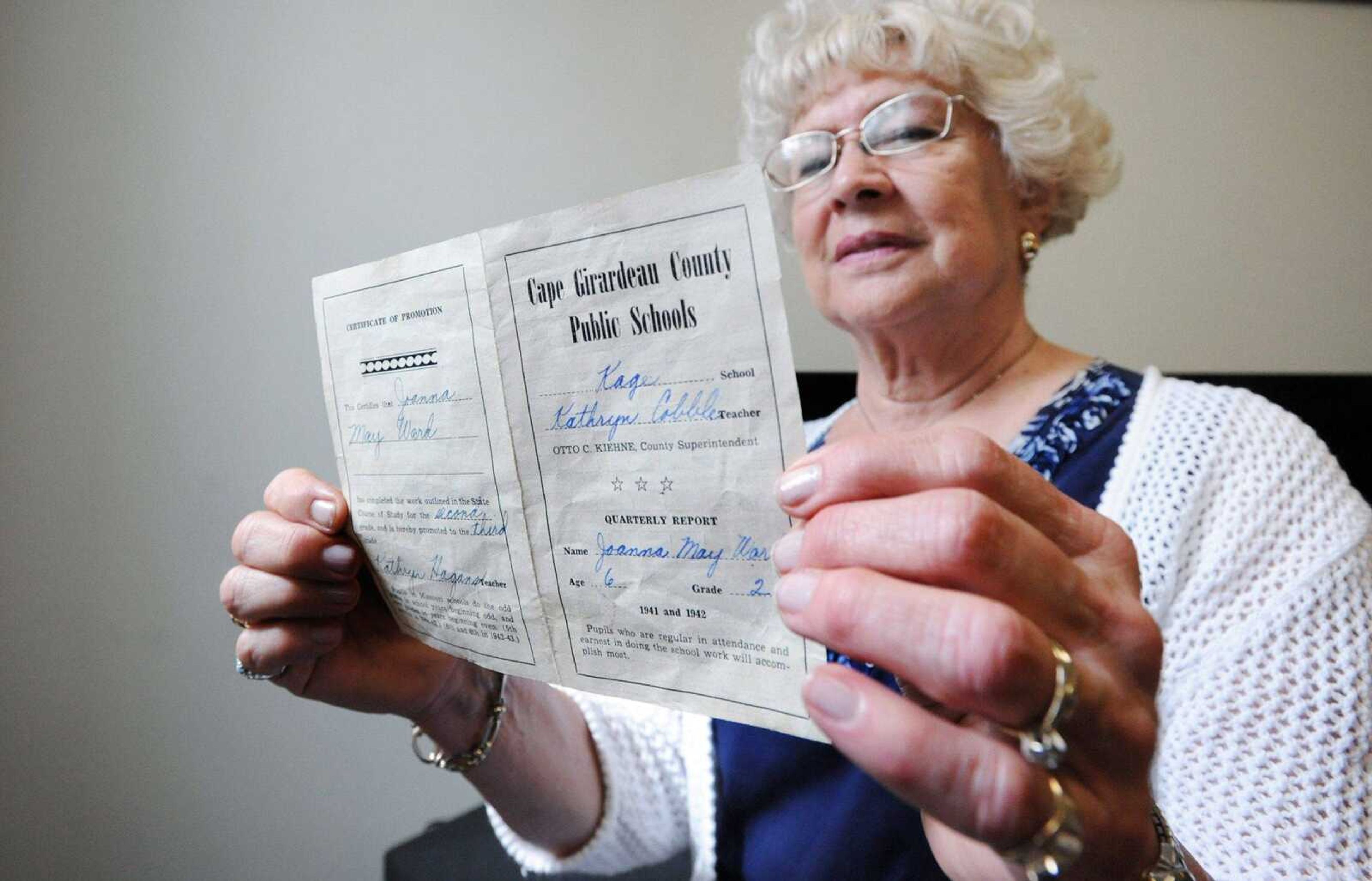 Joanna Proctor holds her report card from the 1941-42 school year inside the renovated Kage School.