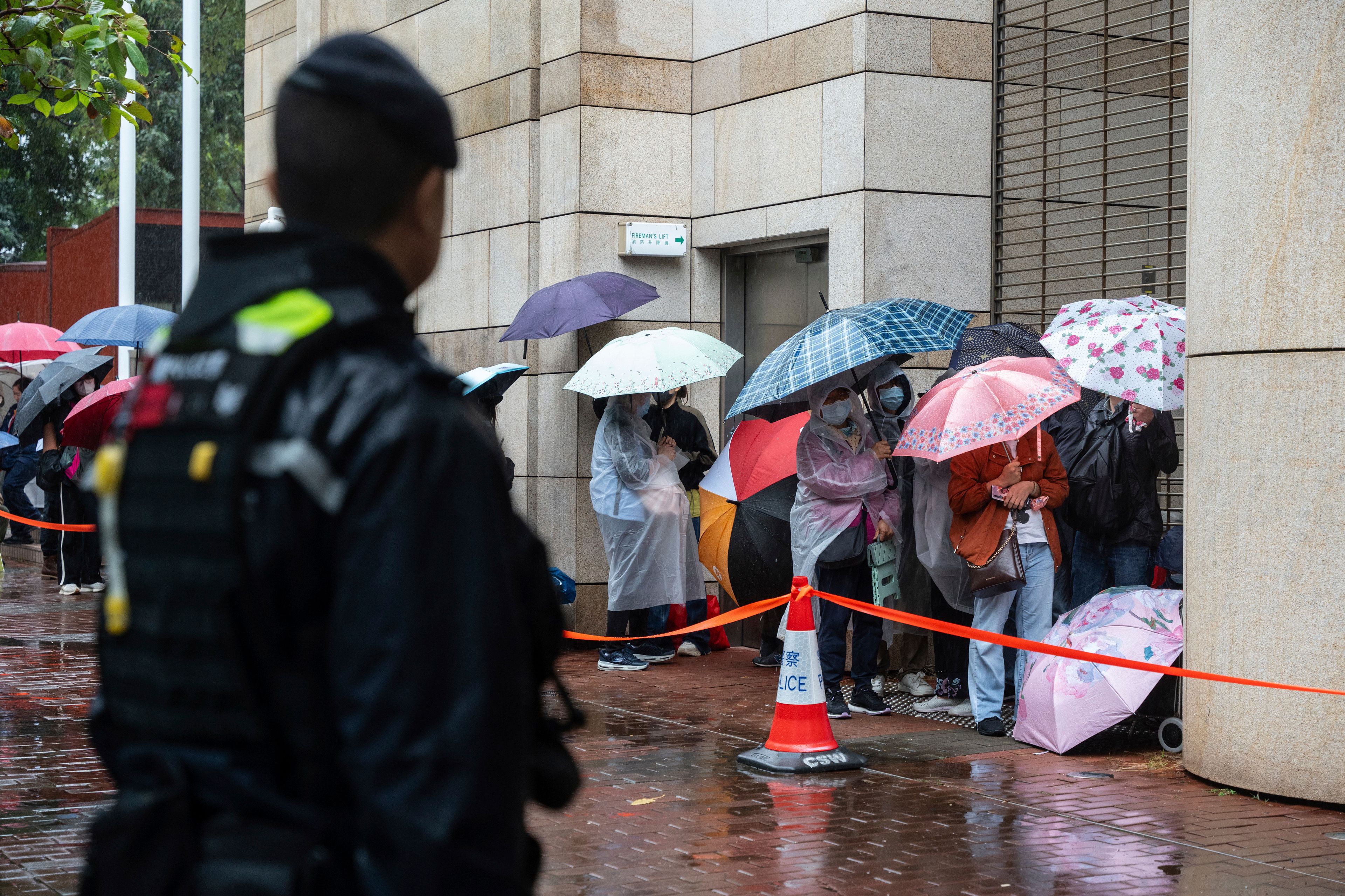 People wait to enter the West Kowloon Magistrates' Courts in Hong Kong, Wednesday, Nov. 20, 2024, ahead of Hong Kong activist publisher Jimmy Lai's national security trial. (AP Photo/Chan Long Hei)