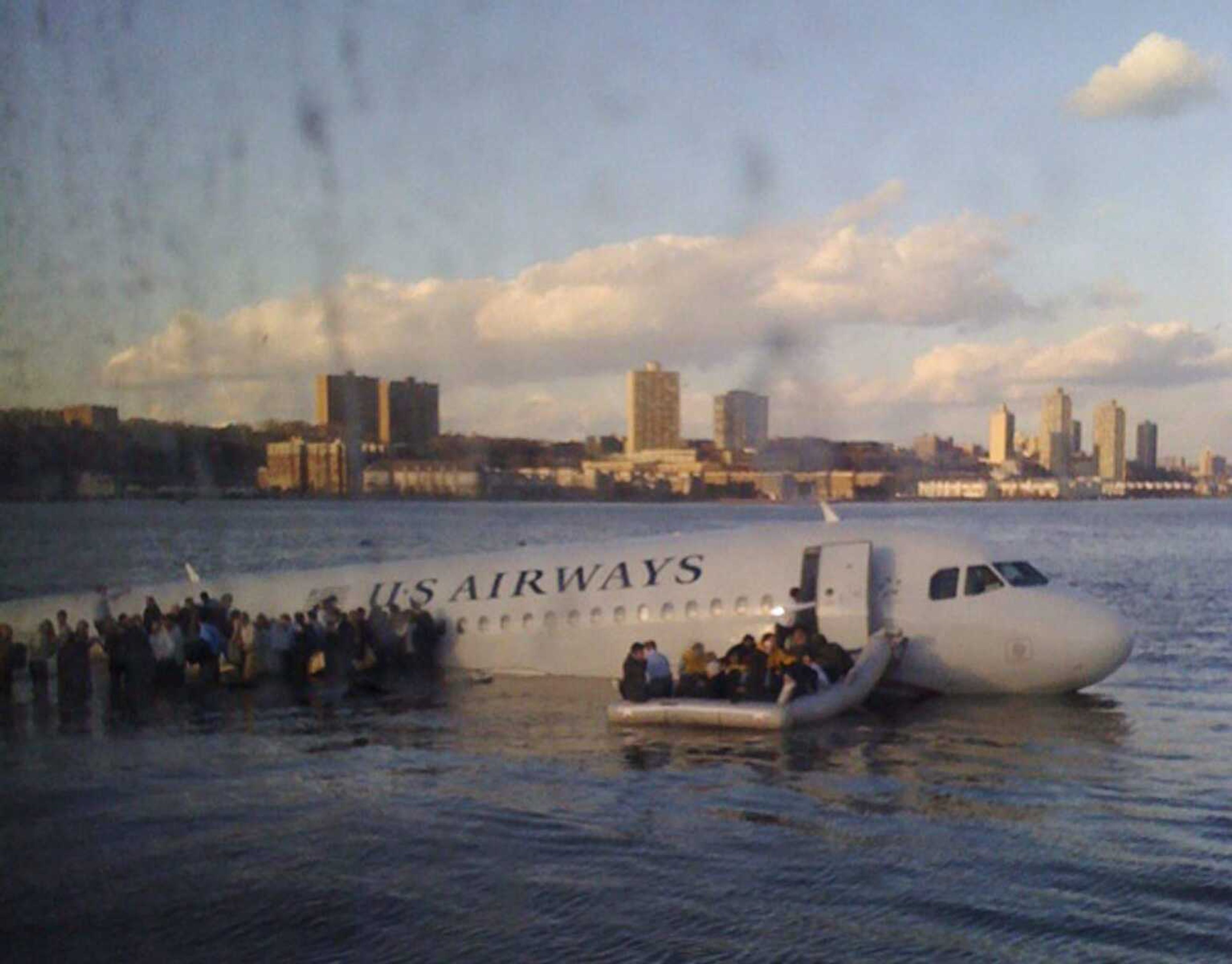 In this photo taken by a passenger on a ferry, airline passengers egress a US Airways Airbus 320 jetliner that safely ditched in the frigid waters of the Hudson River in New York, Thursday Jan. 15, 2009 after a flock of birds knocked out both its engines. All 155 people on board survived. (AP Photo/Janis Krums)