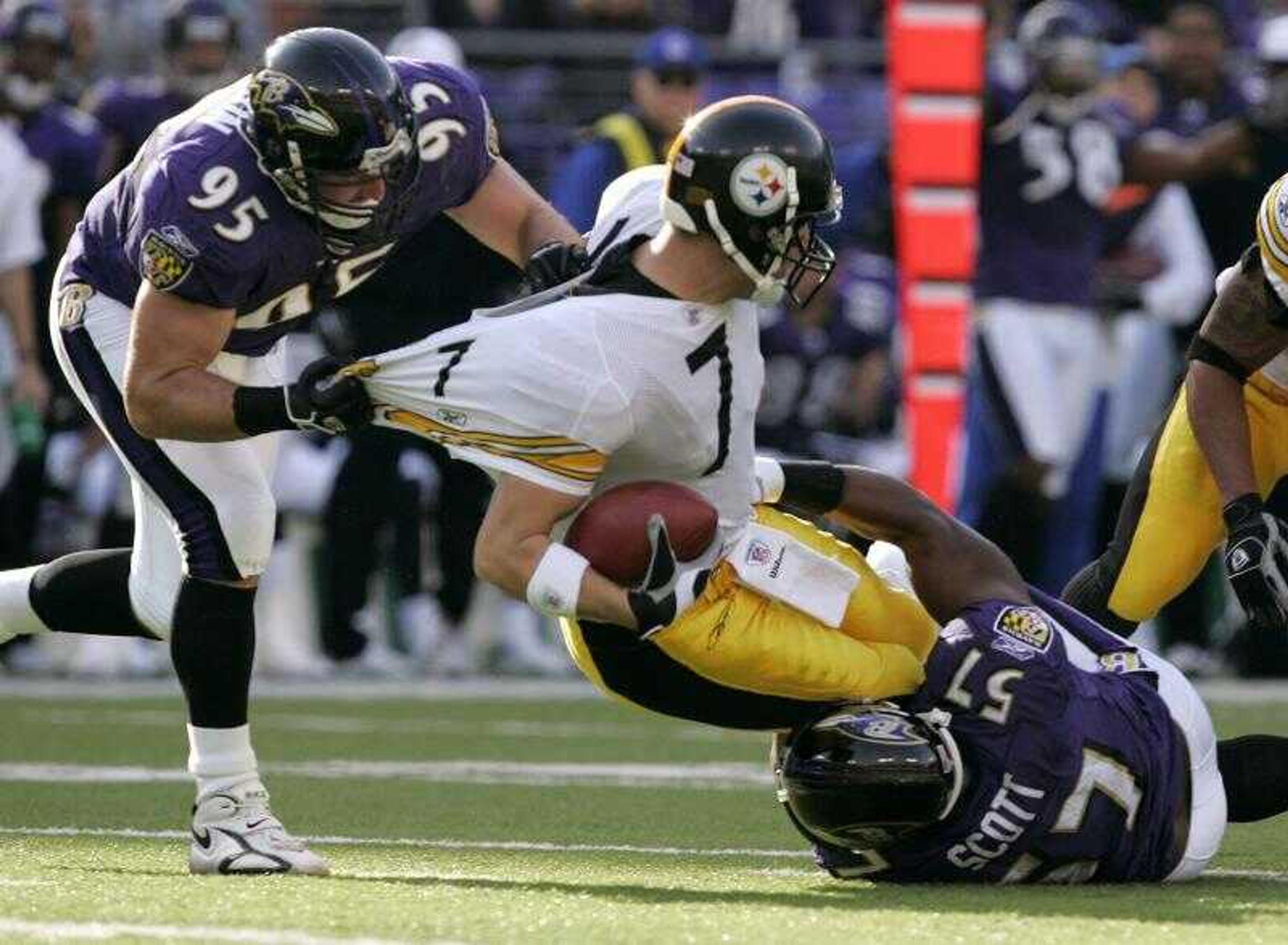 Baltimore Ravens  defensive end Jarret Johnson, left, and linebacker Bart Scott, right, sacked Steelers quarterback Ben Roethlisberger during the first half of Sunday's game. (CHRIS GARDNER ~ Associated Press)