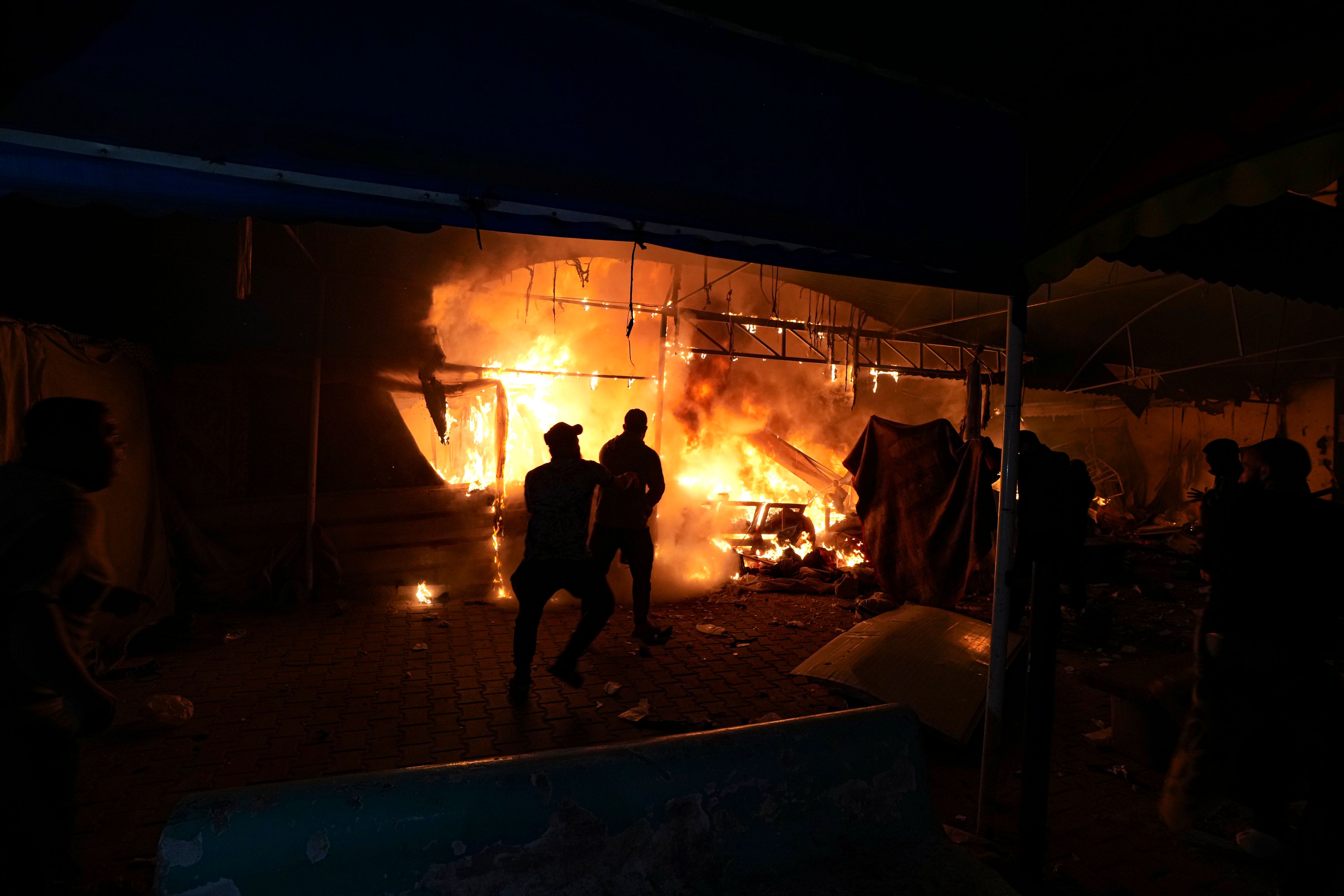 Palestinians react to a fire after an Israeli strike hit a tent area in the courtyard of Al Aqsa Martyrs hospital in Deir al Balah, Gaza Strip, Monday, Oct. 14, 2024. (AP Photo/Abdel Kareem Hana)