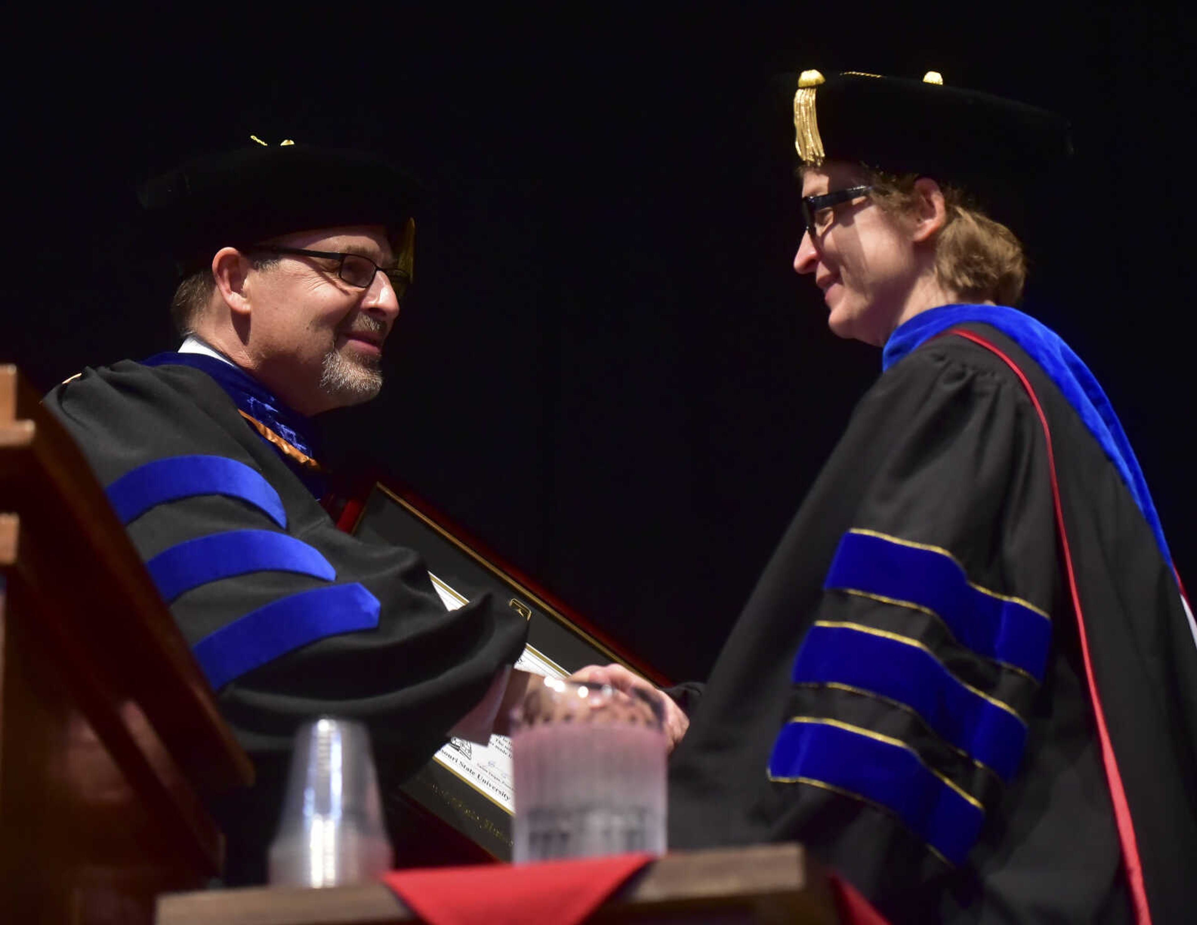 ANDREW J. WHITAKER ~ awhitaker@semissourian.com
Provost Dr. Karl Kunkel gives the Faculty Merit Award to Dr. Dana Schwieger during Southeast Missouri State University graduation Saturday, Dec. 17, 2016 at the Show Me Center in Cape Girardeau.