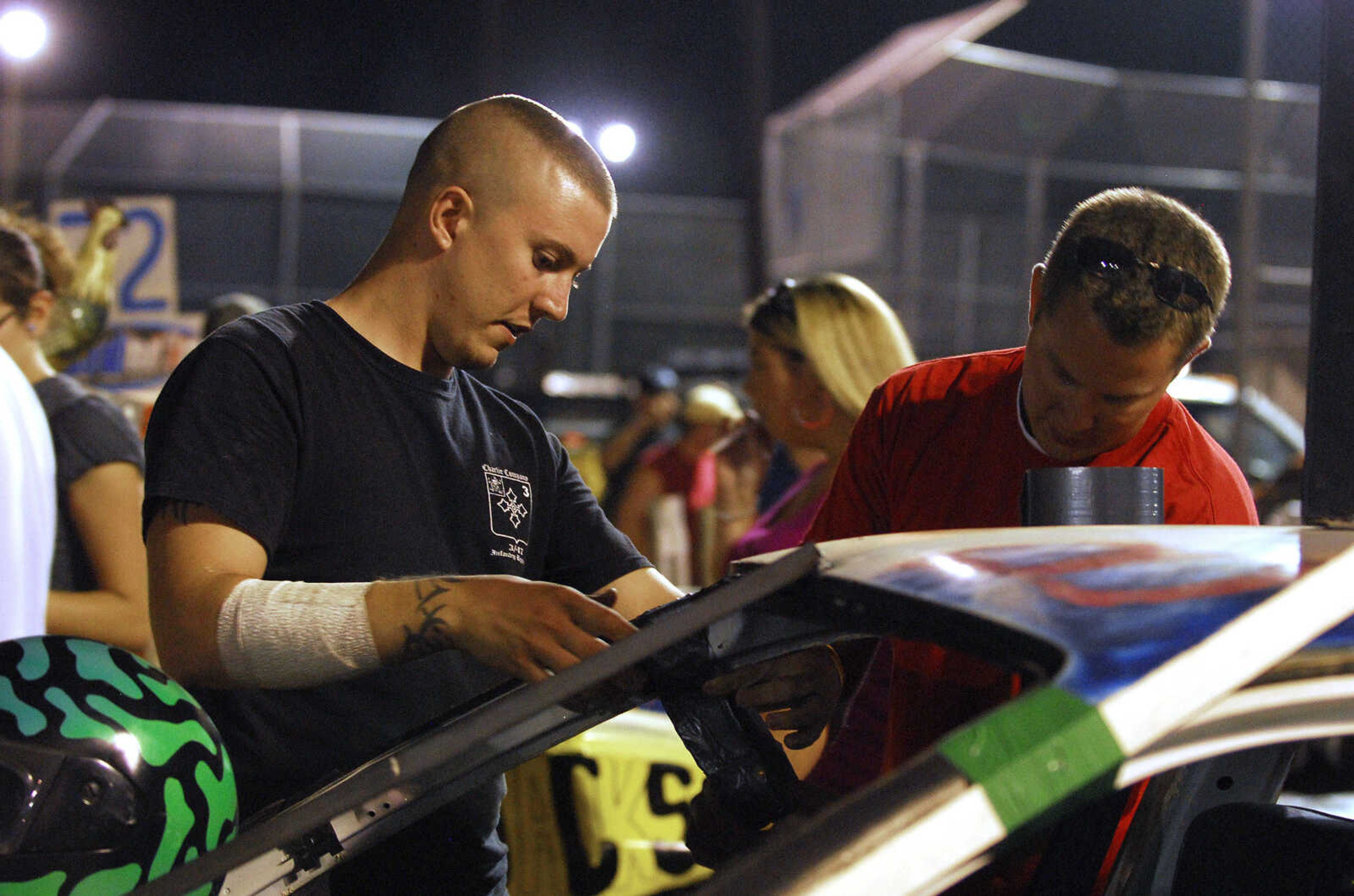 LAURA SIMON~lsimon@semissourian.com
Jordan Barnhart, left, and Matt Feldt make a make-shift handle out of duct tape for the passenger of their derby car Tuesday, September 14, 2010 during the dual demolition derby at the 155th Annual SEMO DIstrict Fair.