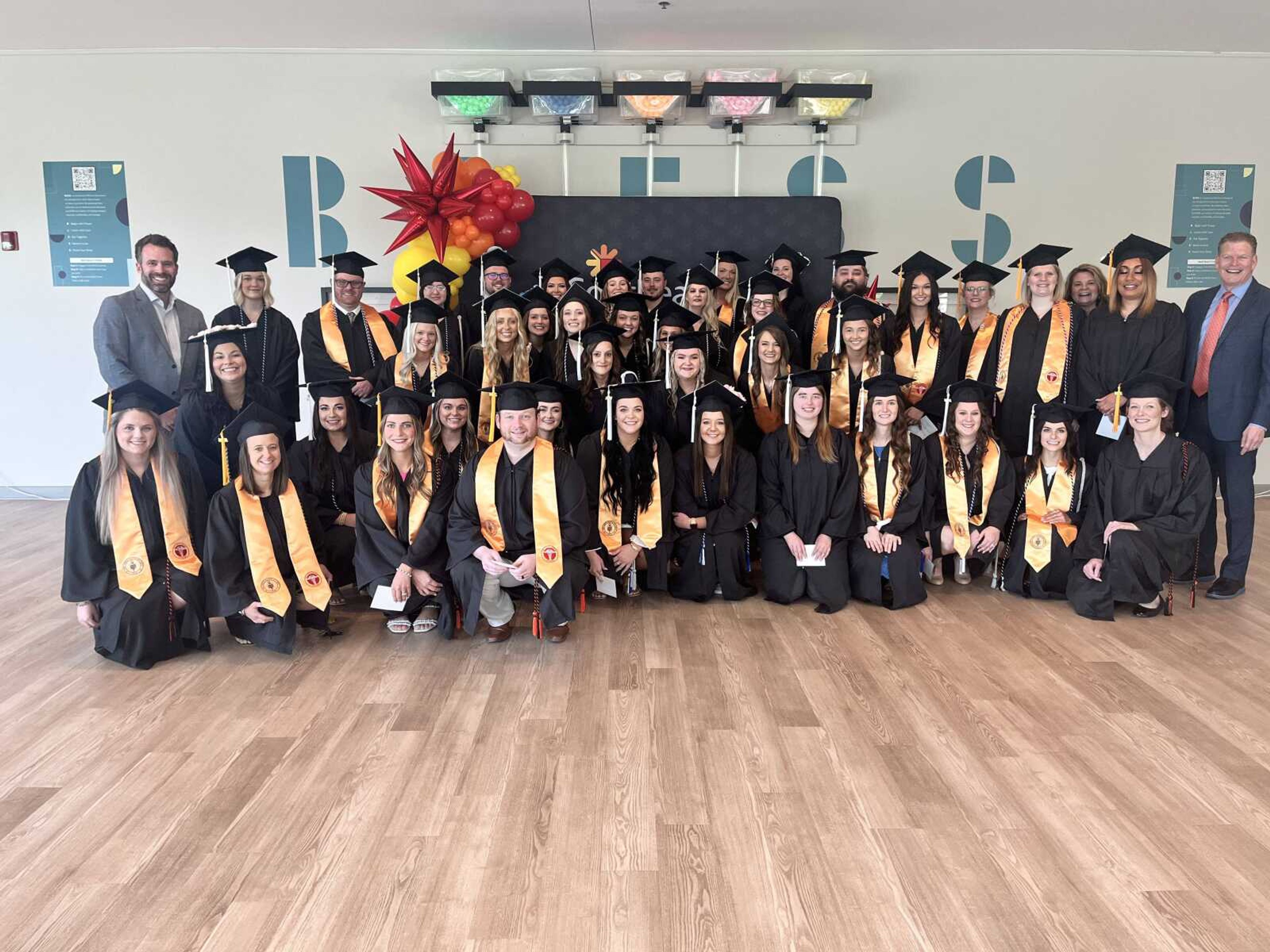 Ryan Geib, left, Mercy Southeast Community President, and Eric Ammons, right, Regional President, are shown with the graduating class of the SoutheastHEALTH College of Nursing and Health Sciences.