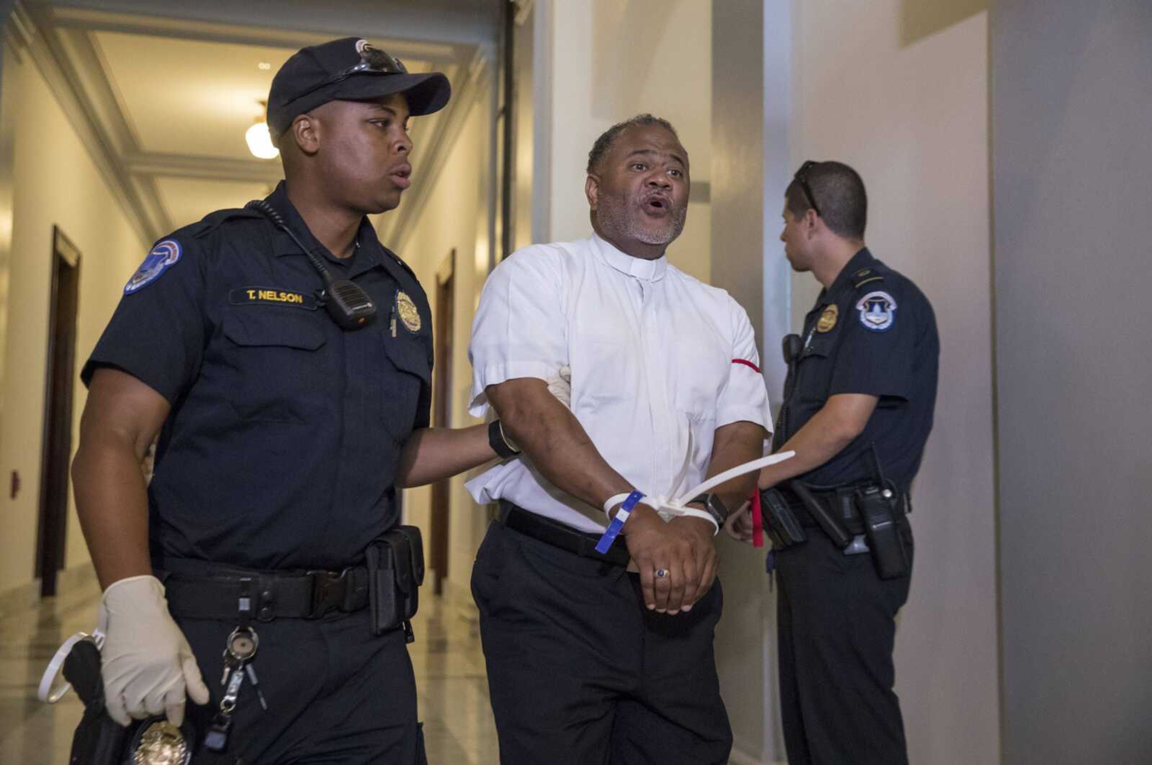 Activists, many members of the clergy, are arrested Thursday by U.S. Capitol Police on Capitol Hill in Washington after protesting against the Republican health-care bill outside the office of Senate Majority Leader Mitch McConnell of Kentucky.