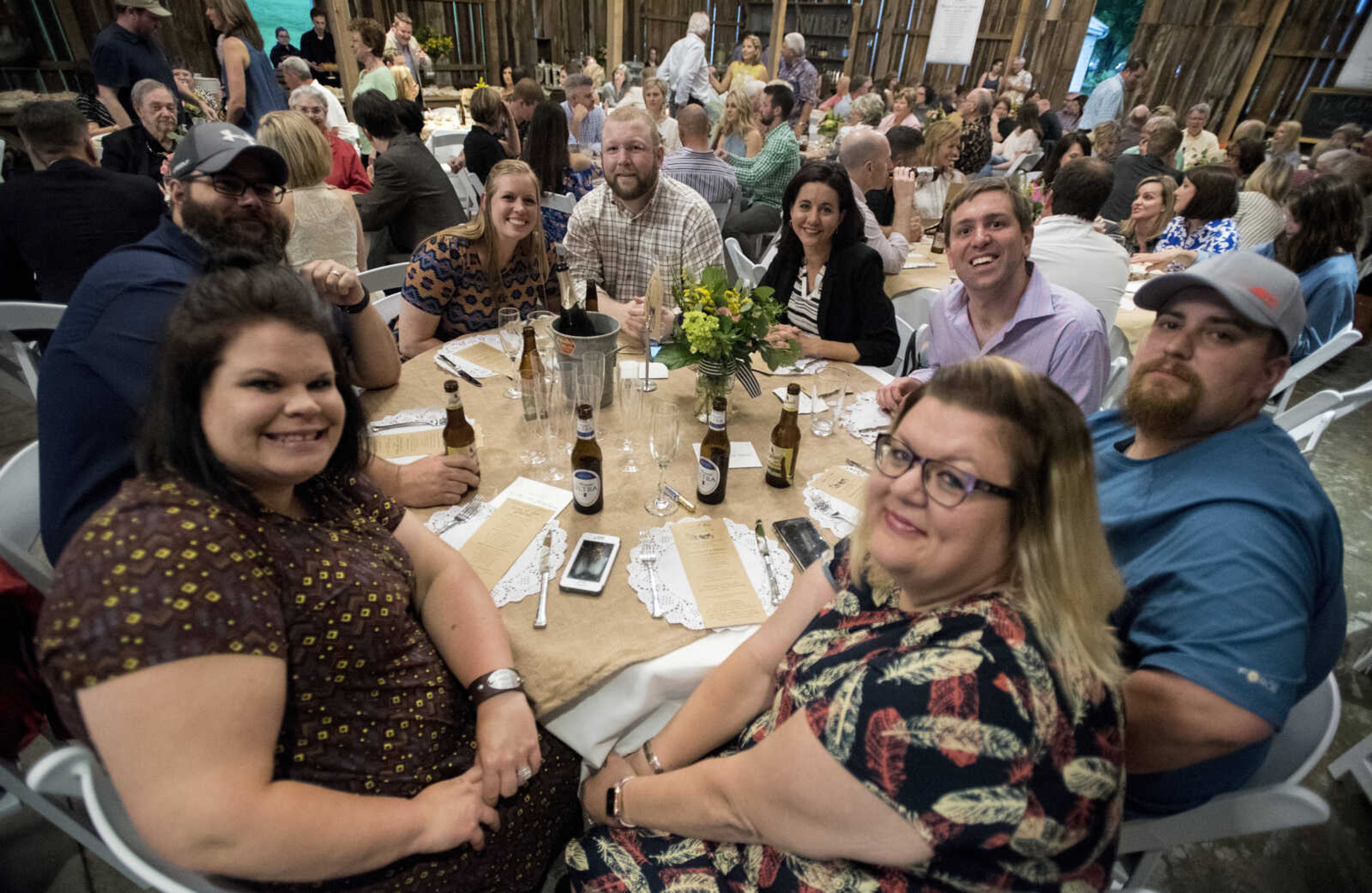 Guests pose for a photo before dinner at Rusted Route Farms on April 29, 2017 during a Swine &amp; Dine pig roast benefiting The Tailor Institute.