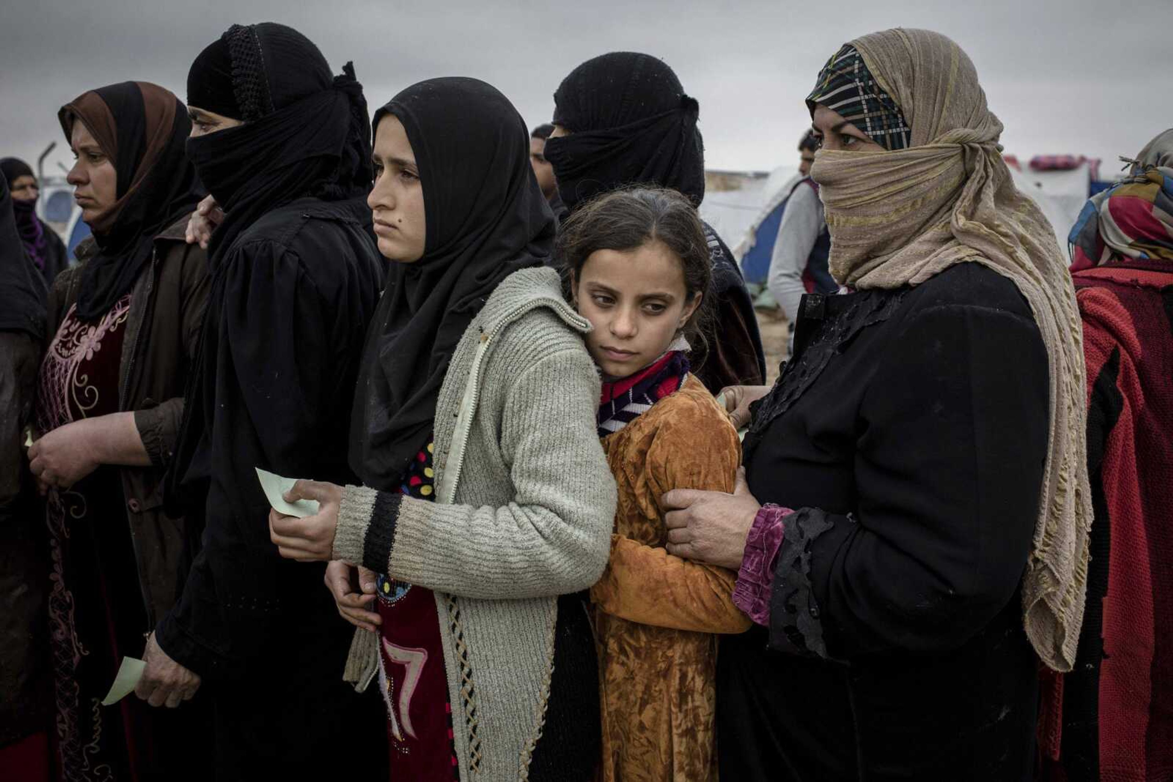 Iraqis displaced from Mosul receive aid distributions Wednesday near Qayara, Iraq.