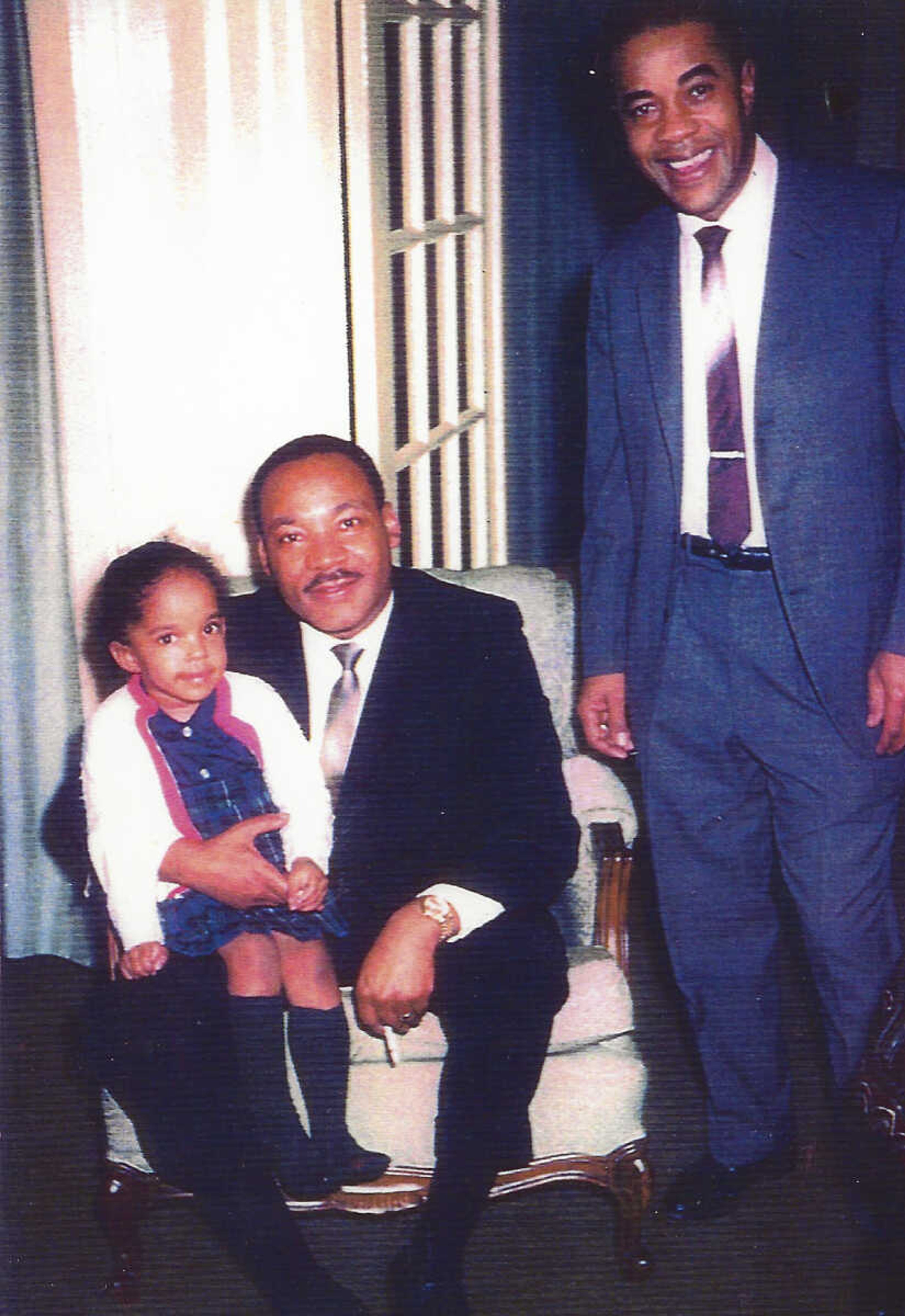 In an undated photo provided by Jawana Jackson, then- 4 year old Jawana sits on the Rev. Martin Luther King Jr s. knee next to her father Dr. Sullivan Jackson at the Jackson home in Selma, Ala. The house which was home base for the Rev. King in planning the Selma to Montgomery marches for Black voting rights, has been acquired by a historical museum in Michigan and will be moved to a site near Detroit for preservation. It will be dismantled starting this summer and trucked to The Henry Ford's Greenfield Village in Dearborn. The project is expected to take two to three years. (Jawana Jackson via AP)