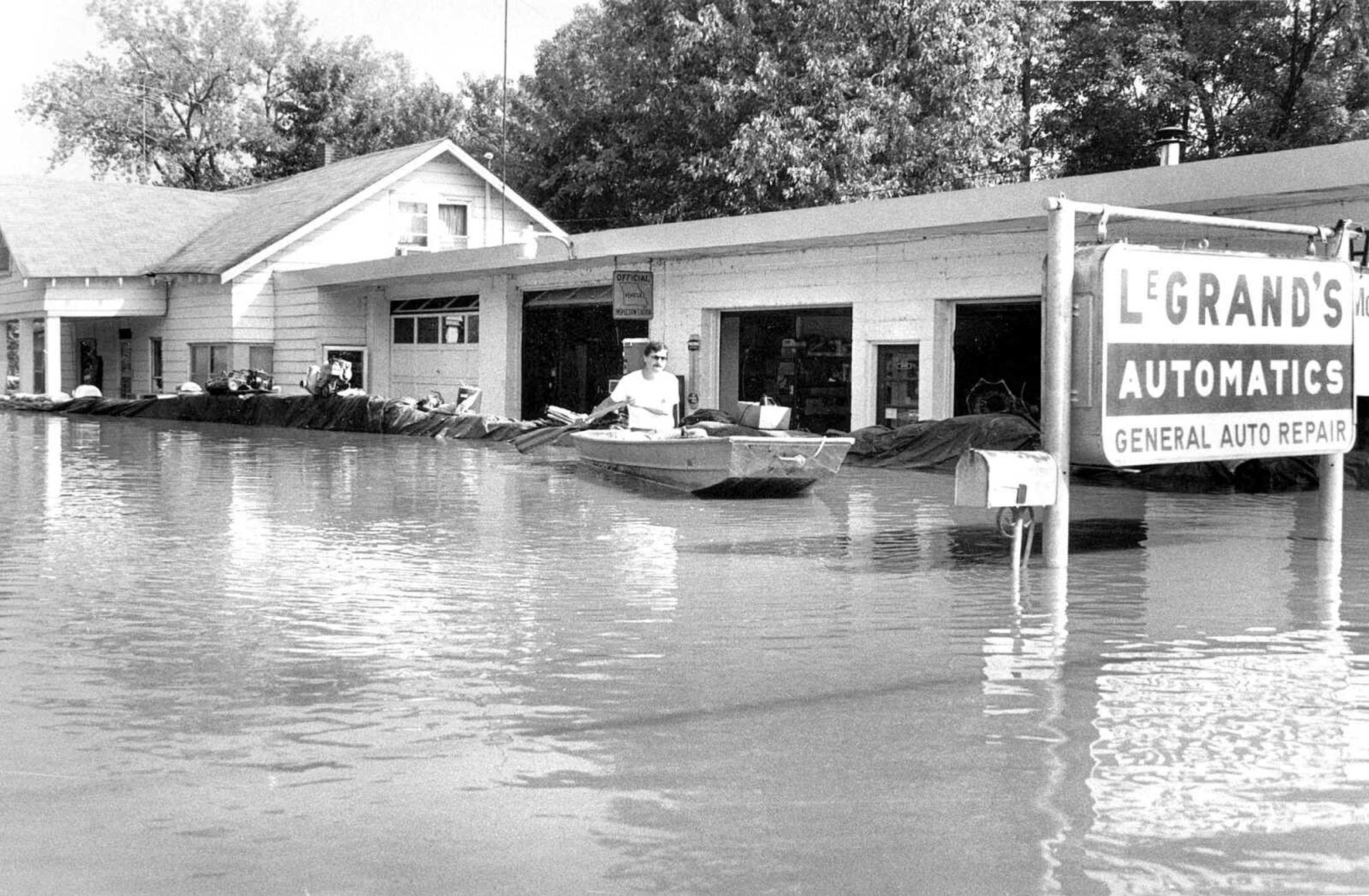 Published Aug. 9, 1993
Although the Mississippi River crested Sunday at 47.9 feet (later revised to 48.49 feet), Tom LeGrand and family members lost the fight to save their business, LeGrand's Transmission, and family home at 1237 N. Water St. A leak developed late Saturday and after a 10 1/2-hour fight, an exhausted family gave up. Water is now four feet deep in the house and five feet deep in the garage. (Missourian archive photo by Melina A. Mara)