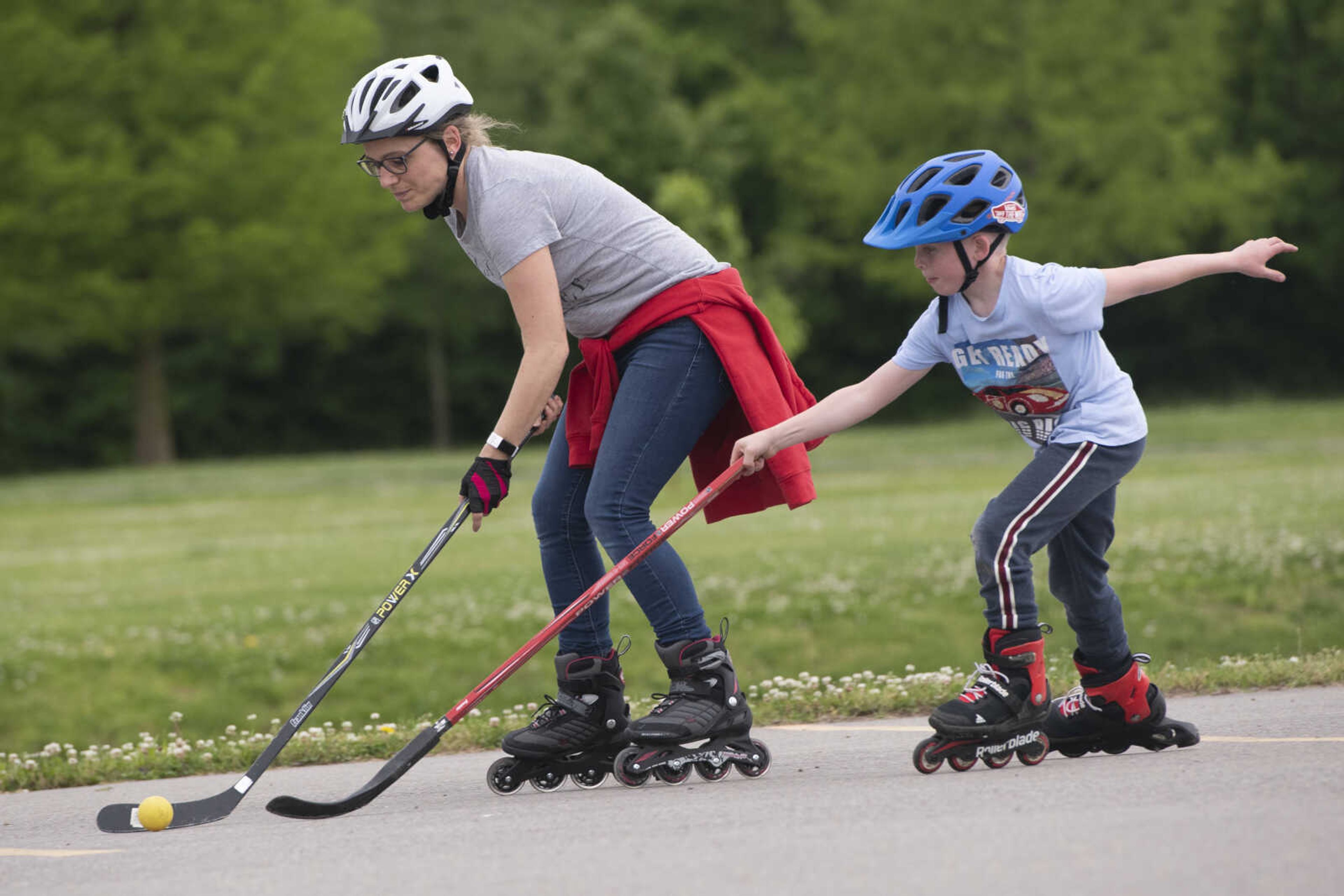 Maren Booch of Cape Girardeau and her son Henri Booch, 7, play hockey Wednesday, May 20, 2020, at a parking lot near Cape Splash Family Aquatic Center in Cape Girardeau.