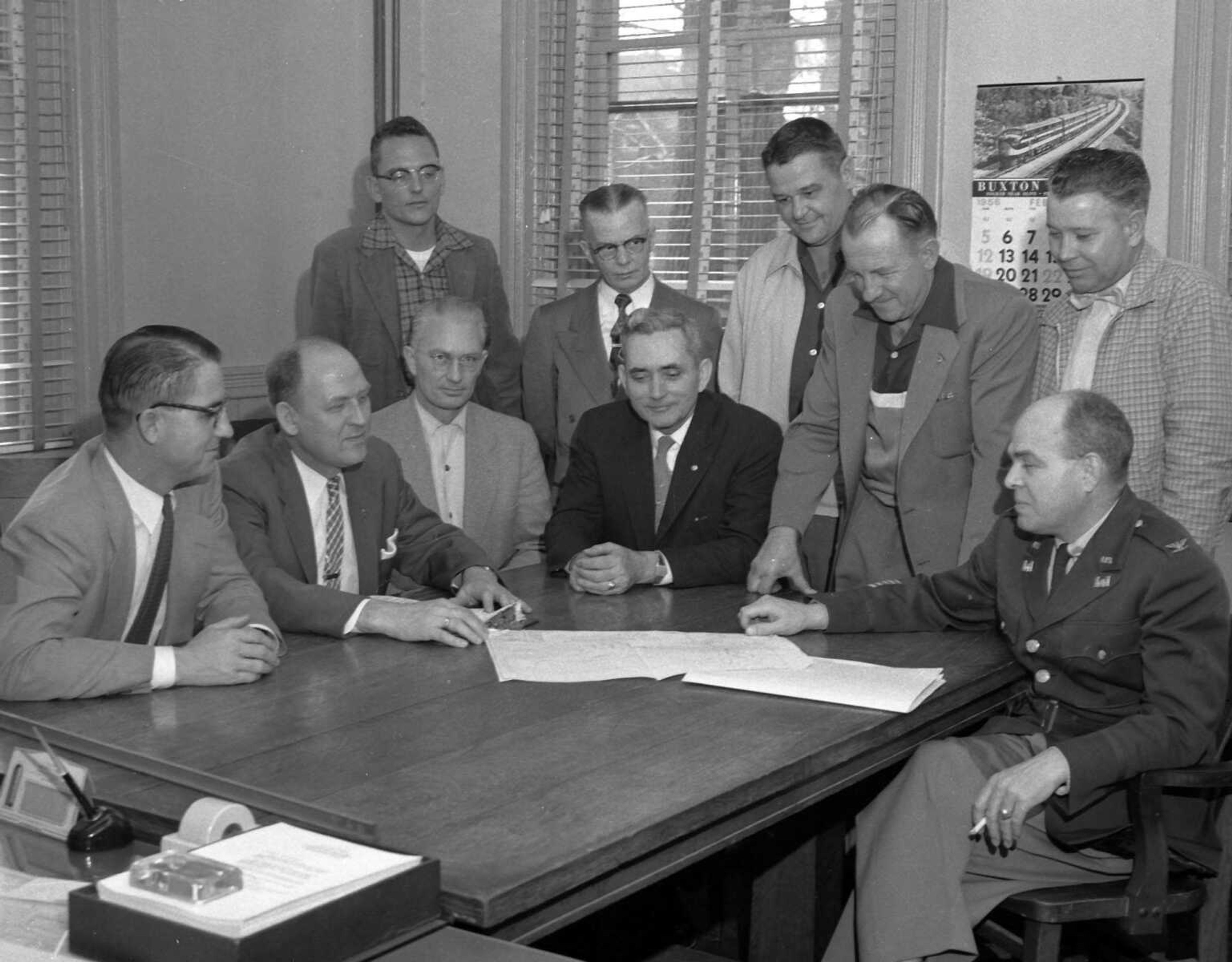 Published Feb. 21, 1956. City officials met with government engineers Friday afternoon to hear of plans for the Main street flood control program now getting started. Seated, from left, City Attorney Gerald B. Rowan, Mayor Narvol A. Randol, Commissioner Leon McLaughlin Commissioner U.G. Pettigrew, and Col. George E. White Jr., of St. Louis, district chief, Corps of Engineers; standing, from left, Robert Parsons, assistant resident engineer; Marshall Gray, information officer for thee engineers; Harold C. Shaver, resident engineer in charge, Commissioner Louis Brune andd Commissioner J.W. McBride. (G.D. Fronabarger, Southeast Missourian archive) [Carrie L. Couch of Cape Girardeau recognized her grandfather: "In the last picture from Pictures from the Past #14 with Mayor Narvol A. Randol, is my grandfather, U.G. Pettigrew. He is seated fourth from the left in the black suit. Thank you for publishing all of these great photos!" Bill Stone commented: "That is definitely Brownie McBride standing on the far right (next to) the gentleman in the uniform."]