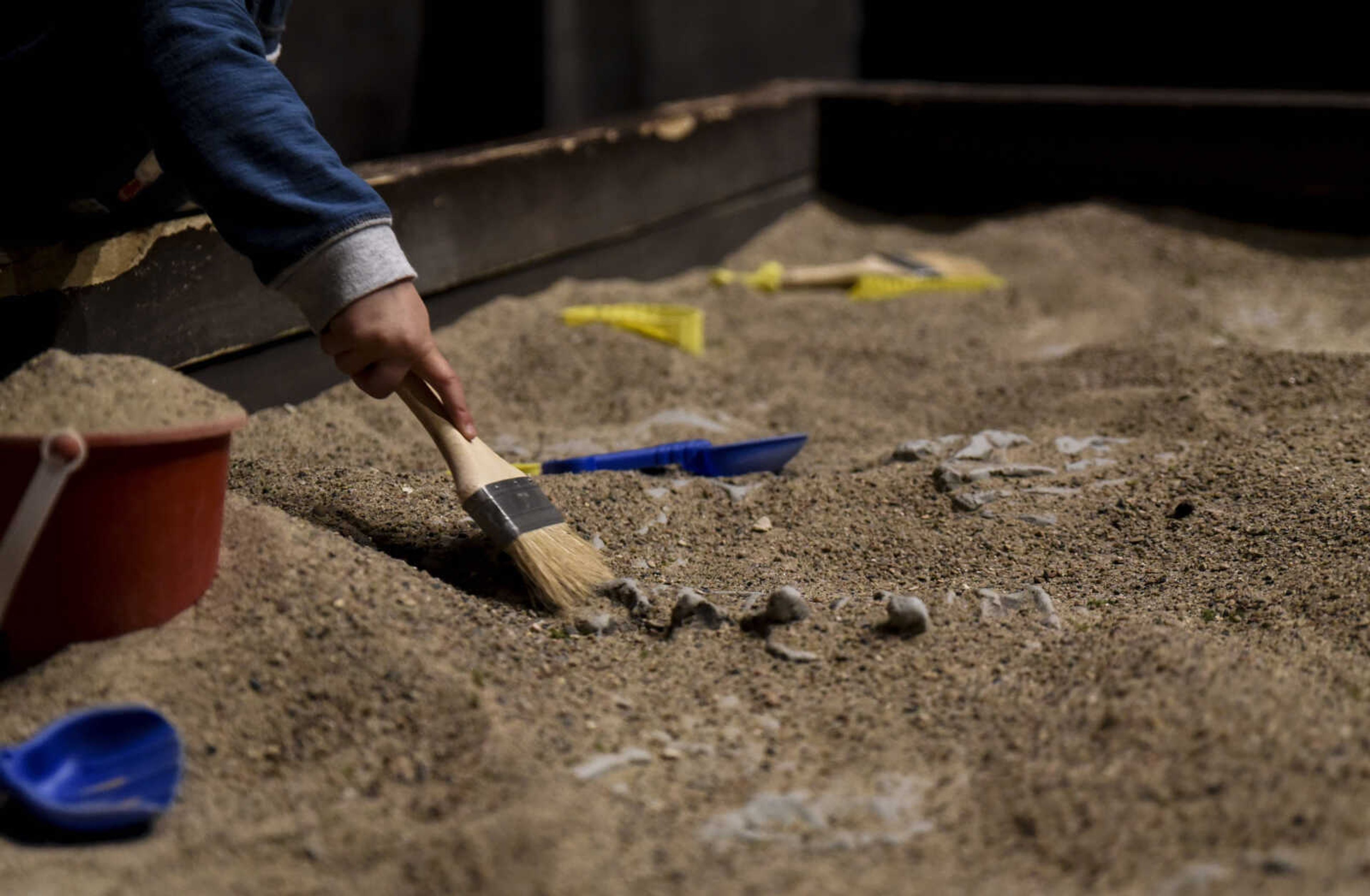 Mason Wills, 2, digs in the fossil sandbox at Jurassic Quest Friday, April 27, 2018, at the Show Me Center in Cape Girardeau.