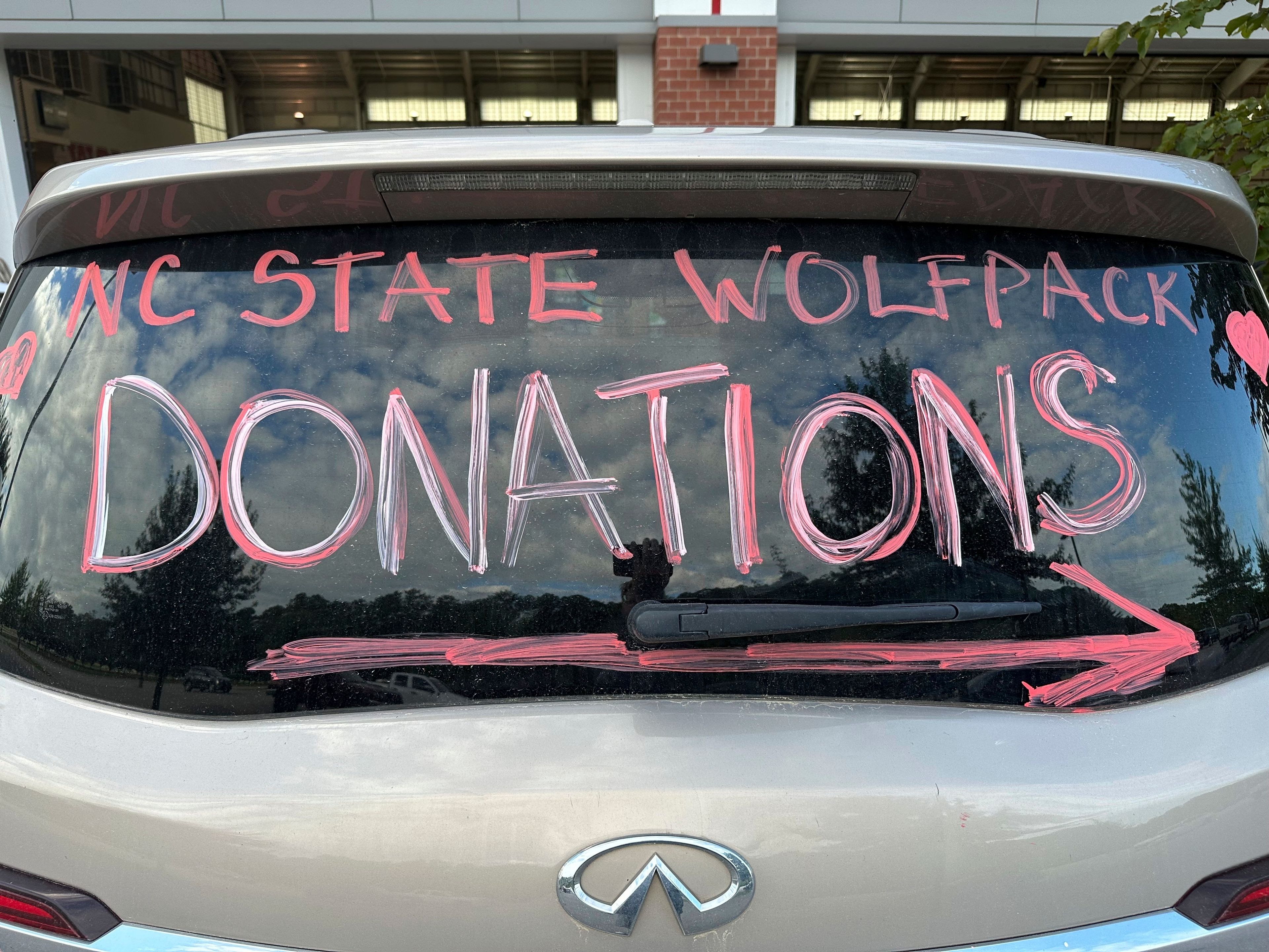 A makeshift sign in a vehicle window helps direct people arriving at a donation drive led by N.C. State defensive end Davin Vann to collect supplies to help Hurricane Helene victims in western North Carolina, Wednesday, Oct. 2, 2024 in Raleigh, N.C. (AP Photo/Aaron Beard)