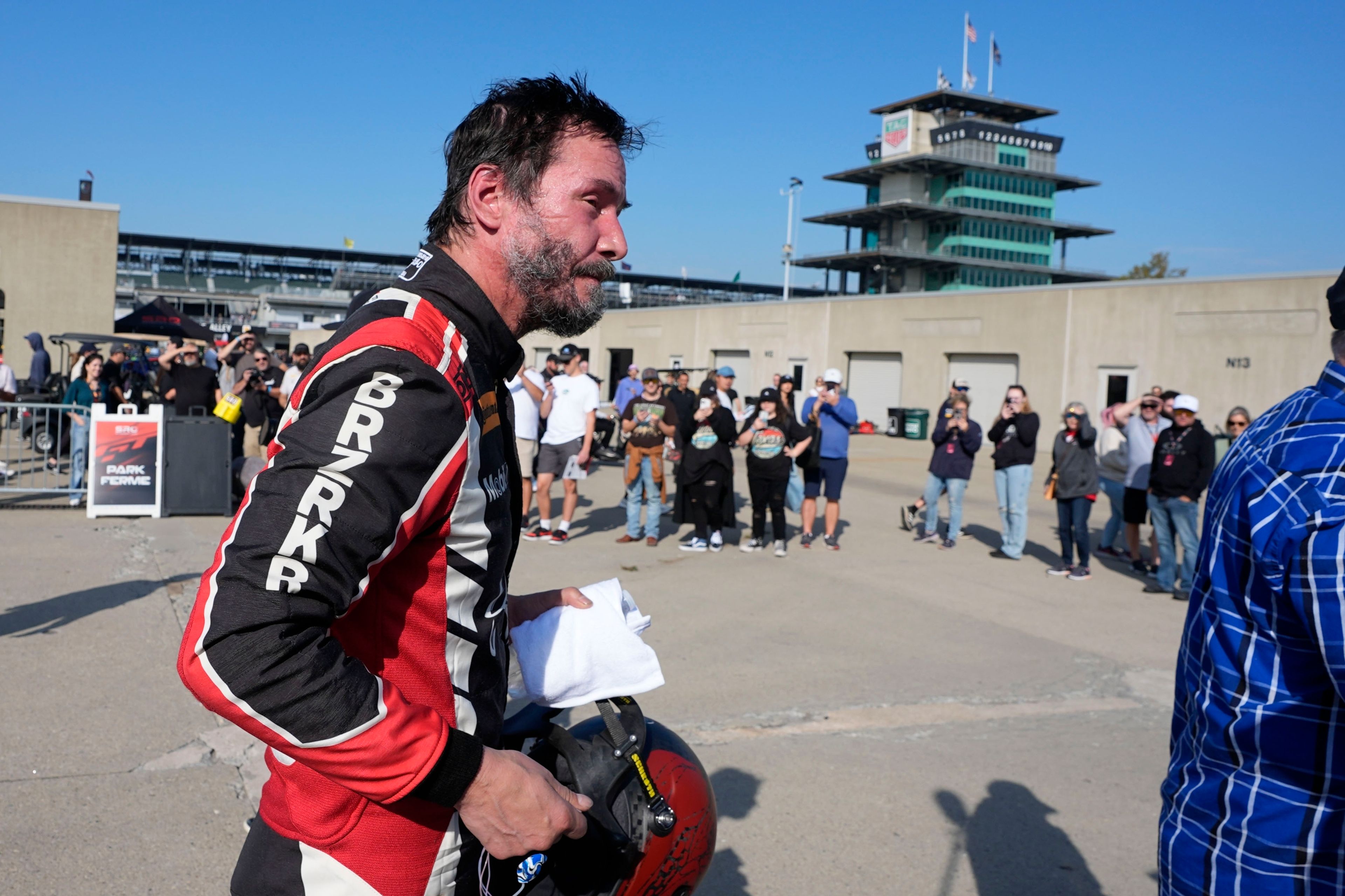 Keanu Reeves walks in the garage area following a GR Cup Series auto race at Indianapolis Motor Speedway, Saturday, Oct. 5, 2024, in Indianapolis. (AP Photo/Darron Cummings)