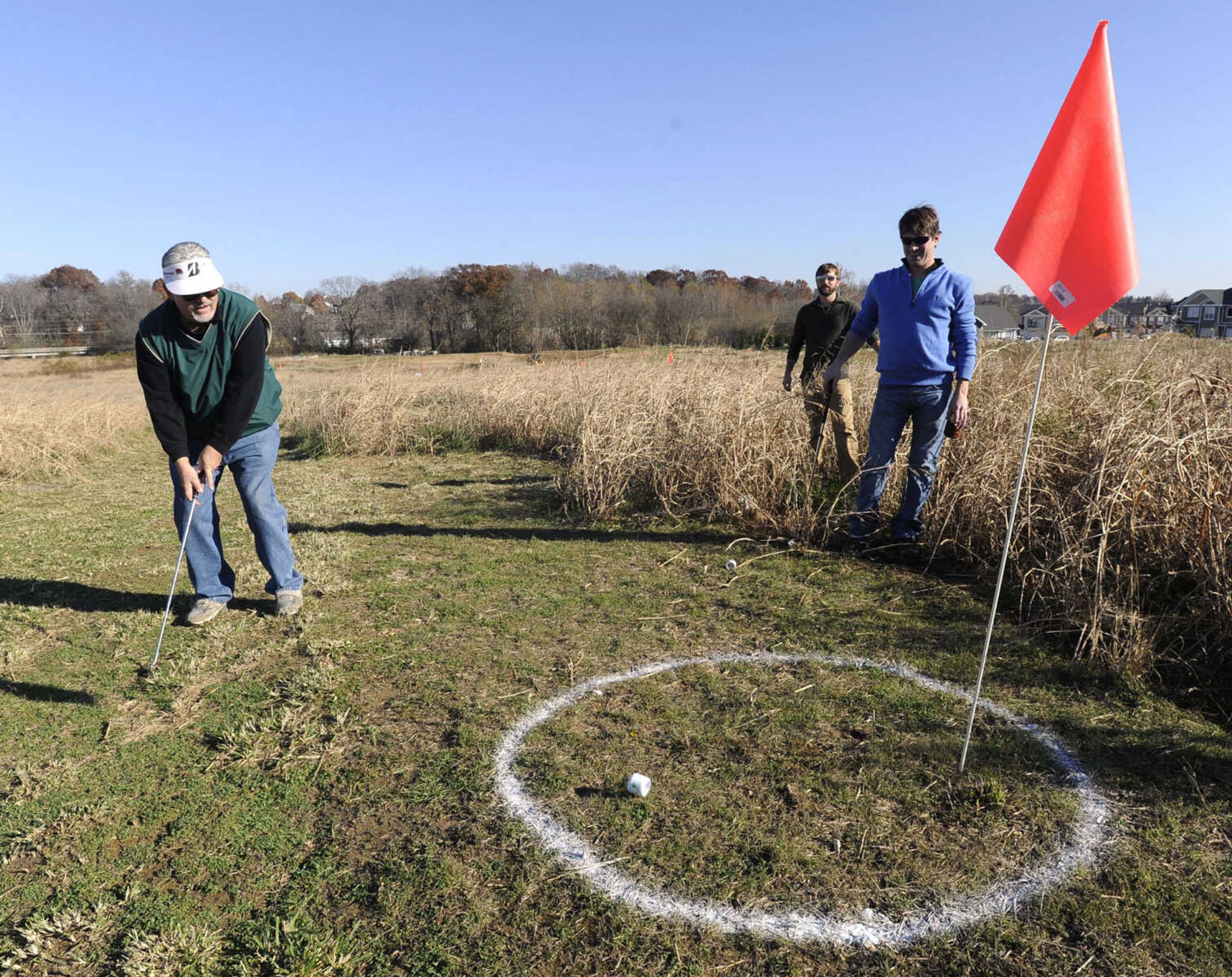 Brad Brune watches his putt to the ninth hole with Charles Evans, right, and Andrew Essner at the Discover Playhouse Open.